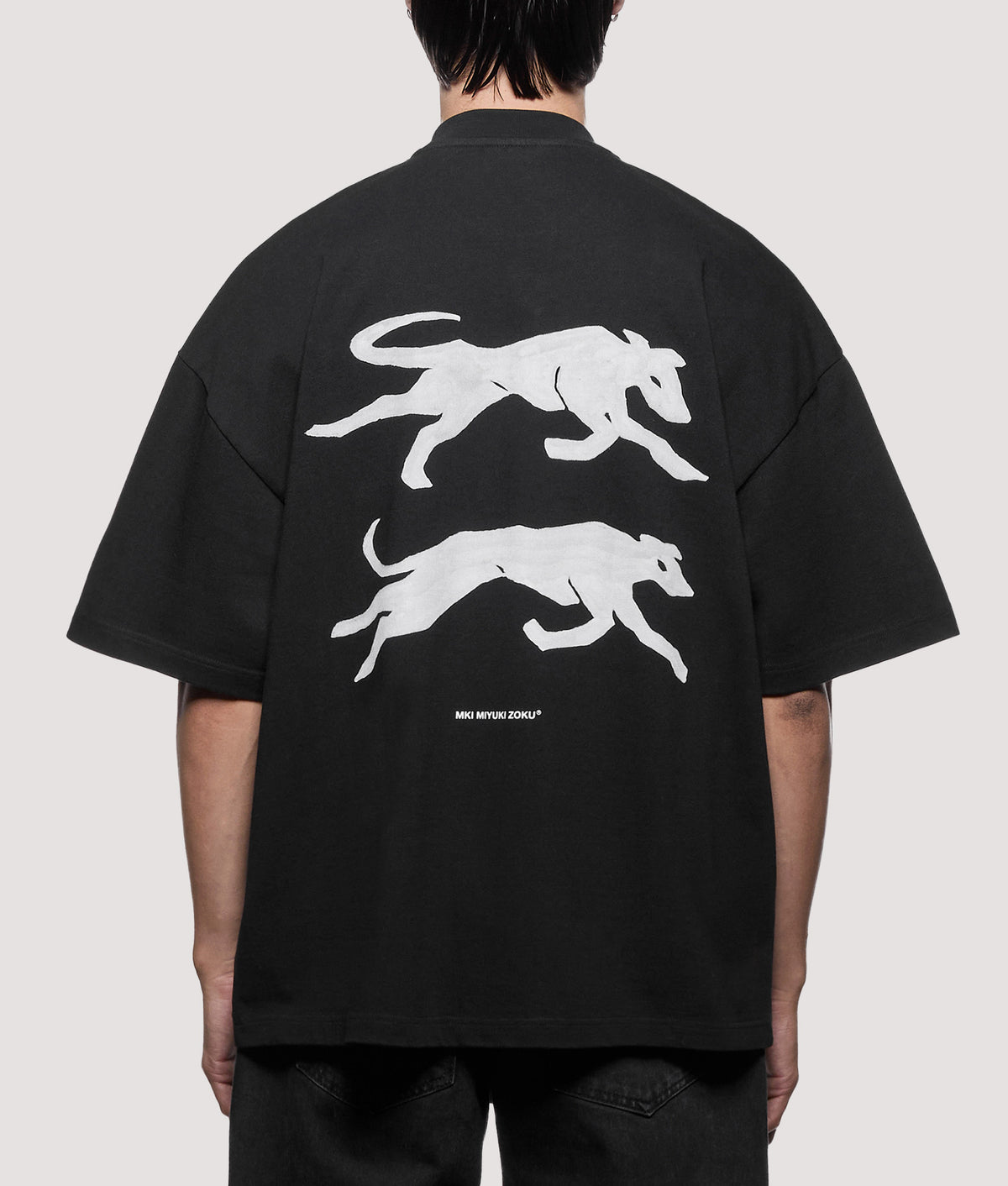 MKI MIYUKI ZOKU Oversized Box Fit Greyhound T-Shirt in Black at EQVVS Menswear. Model back shot.