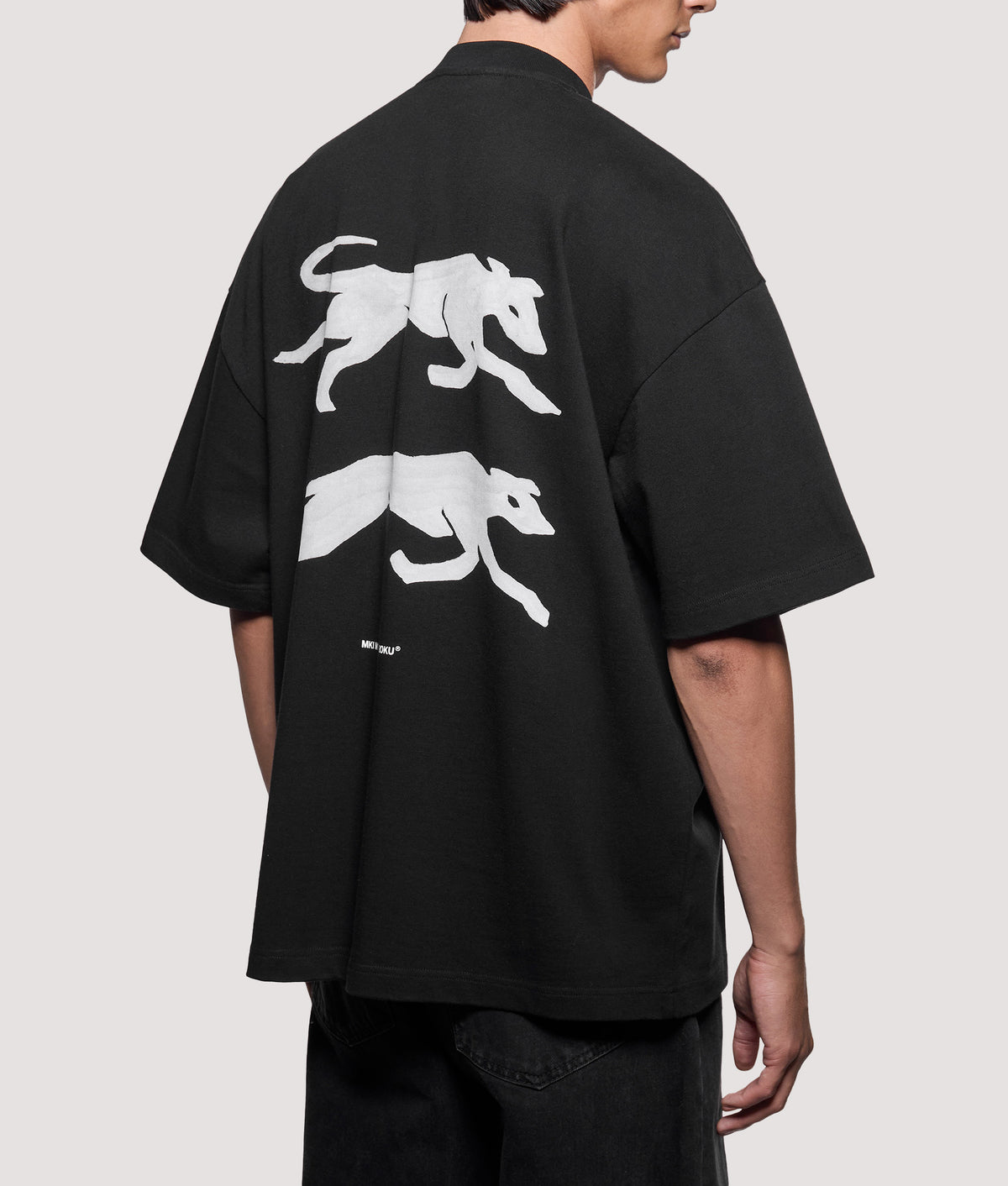 MKI MIYUKI ZOKU Oversized Box Fit Greyhound T-Shirt in Black at EQVVS Menswear. Model back shot.
