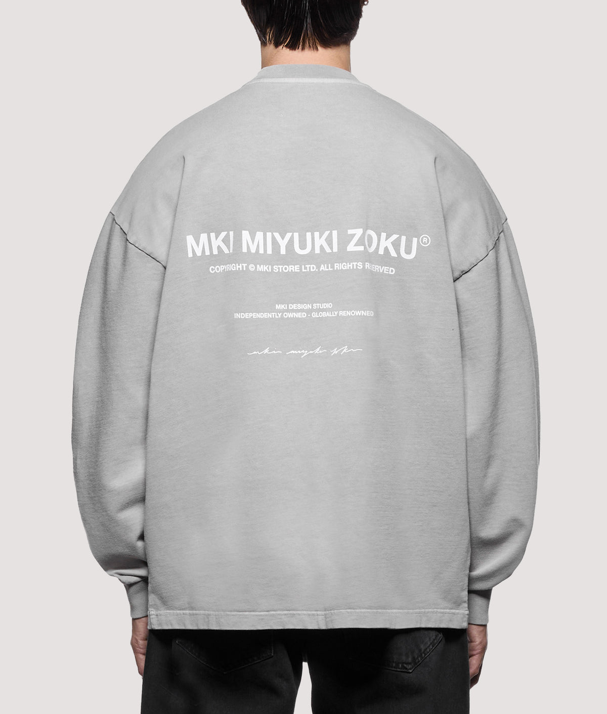 MKI MIYUKI ZOKU Oversized Box Fit Design Studio Long Sleeve T-Shirt in Pigment Stone at EQVVS Menswear. Model back shot.