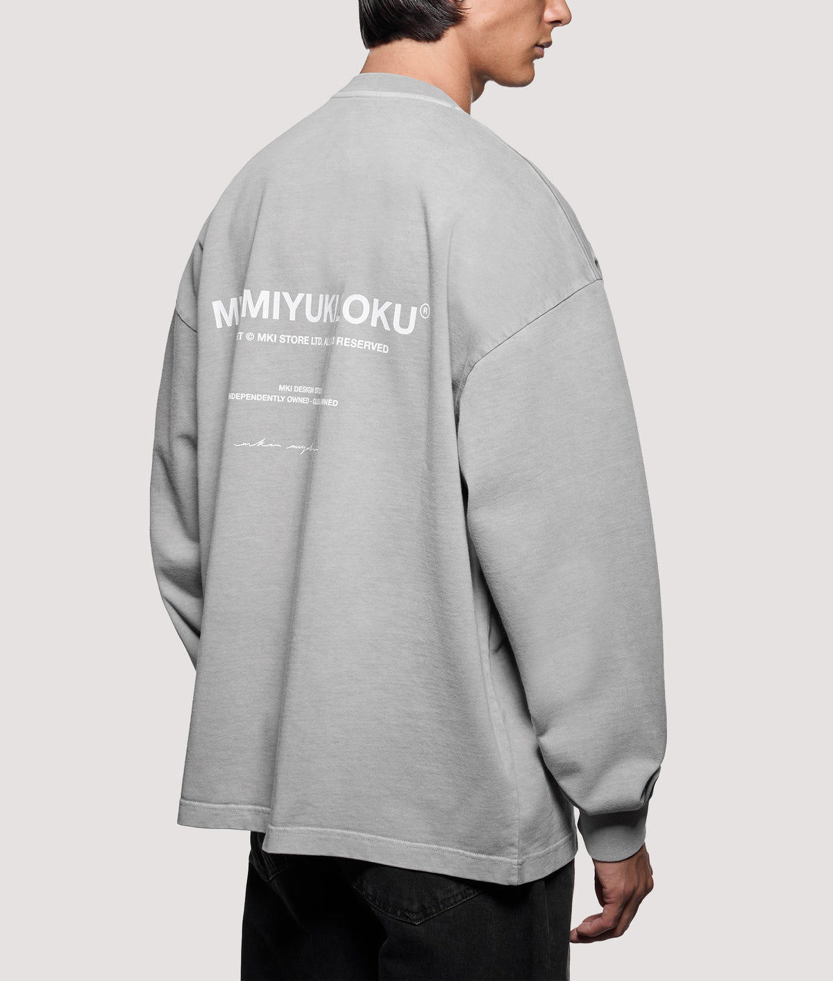 MKI MIYUKI ZOKU Oversized Box Fit Design Studio Long Sleeve T-Shirt in Pigment Stone at EQVVS Menswear. Angled model back shot.
