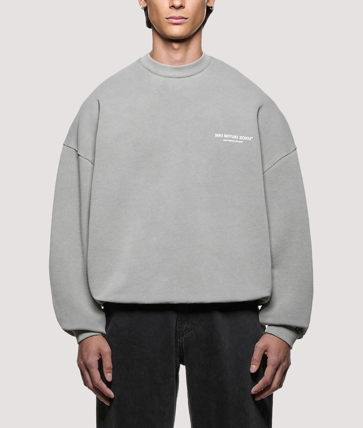 MKI MIYUKI ZOKU Oversized Box Fit Design Studio Crewneck Sweatshirt in Pigment Stone at EQVVS Menswear. Model front shot.