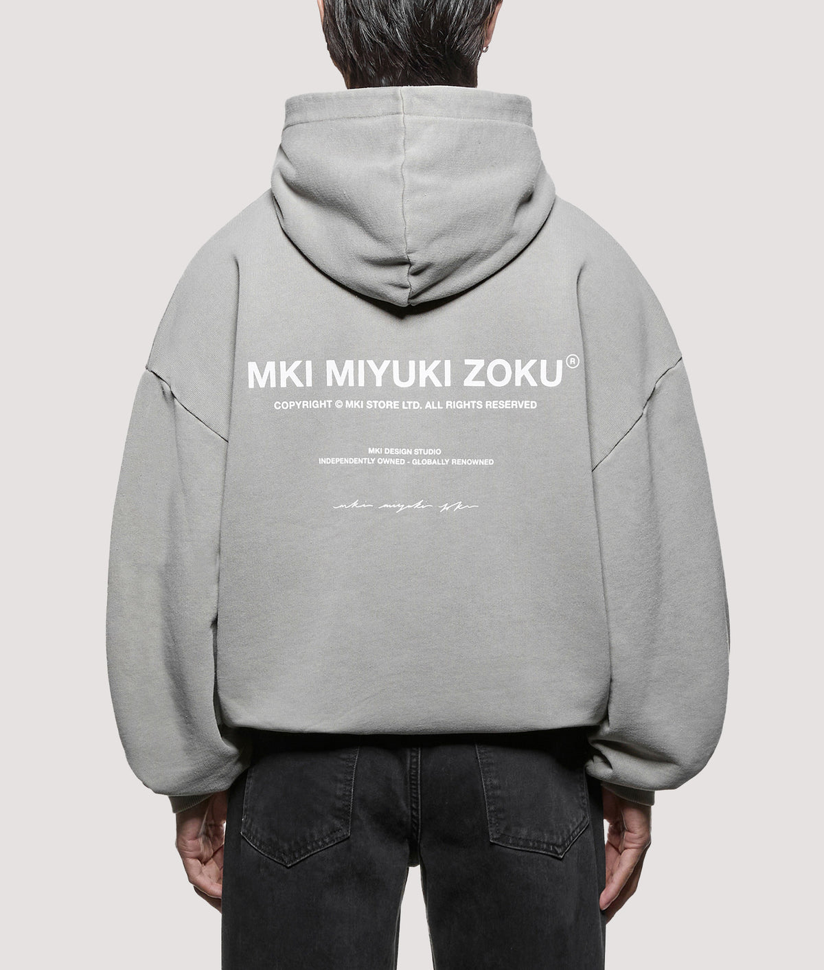 MKI MIYUKI ZOKU Oversized Box Fit Design Studio Hoodie in Pigment Stone at EQVVS Menswear. Model back shot.