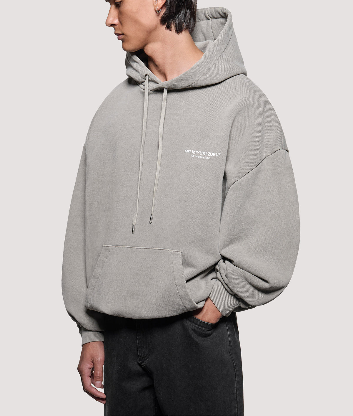 MKI MIYUKI ZOKU Oversized Box Fit Design Studio Hoodie in Pigment Stone at EQVVS Menswear. Angled model front shot.