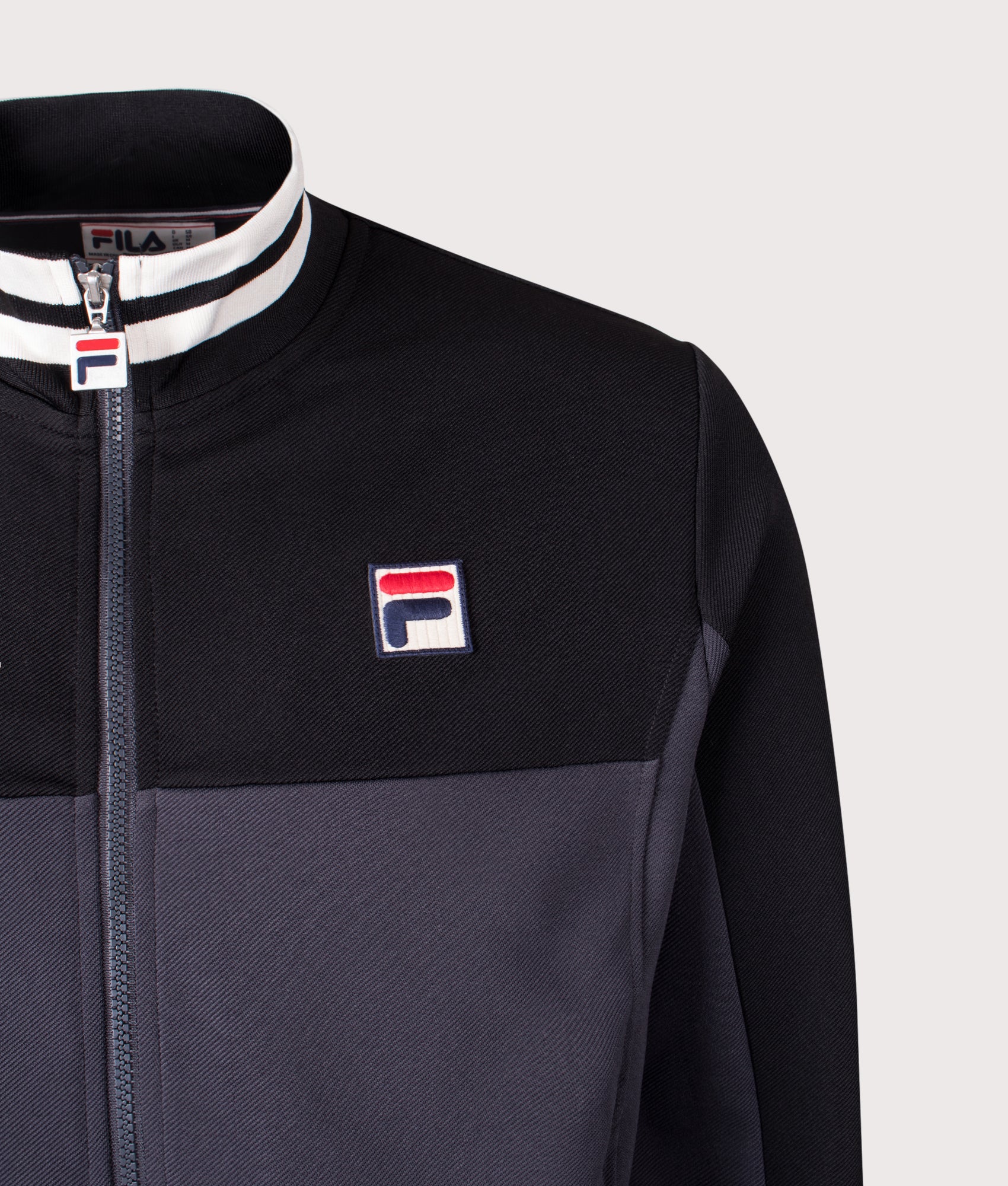 Tiebraker Funnel Neck Track Jacket by FILA in Black/Charcoal/Gardenia. Shot by EQVVS. Detail shot.