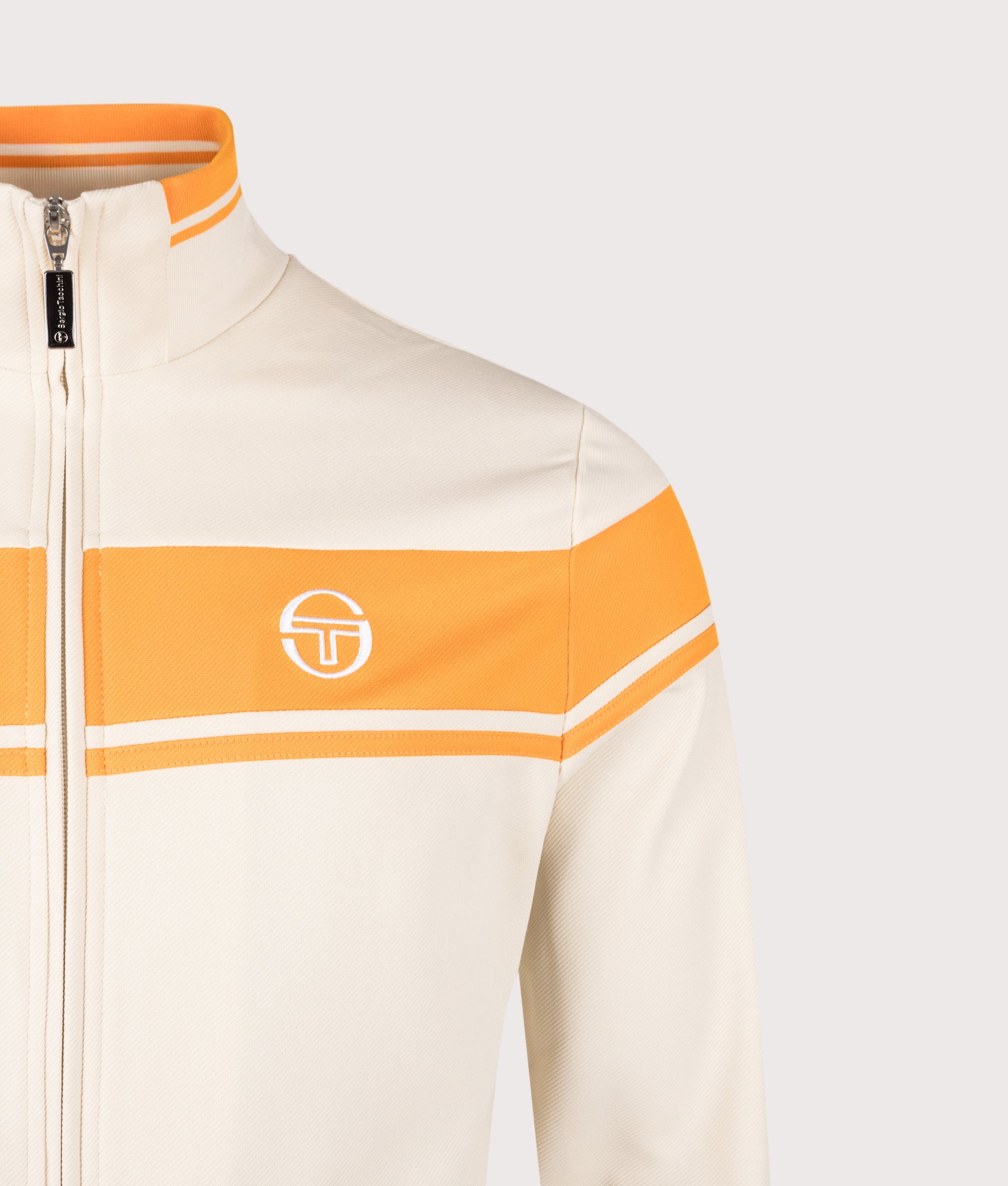 Sergio Tacchini Damarindo Track Top in Sandshell and Orange Pepper at EQVVS Menswear. Details shot.