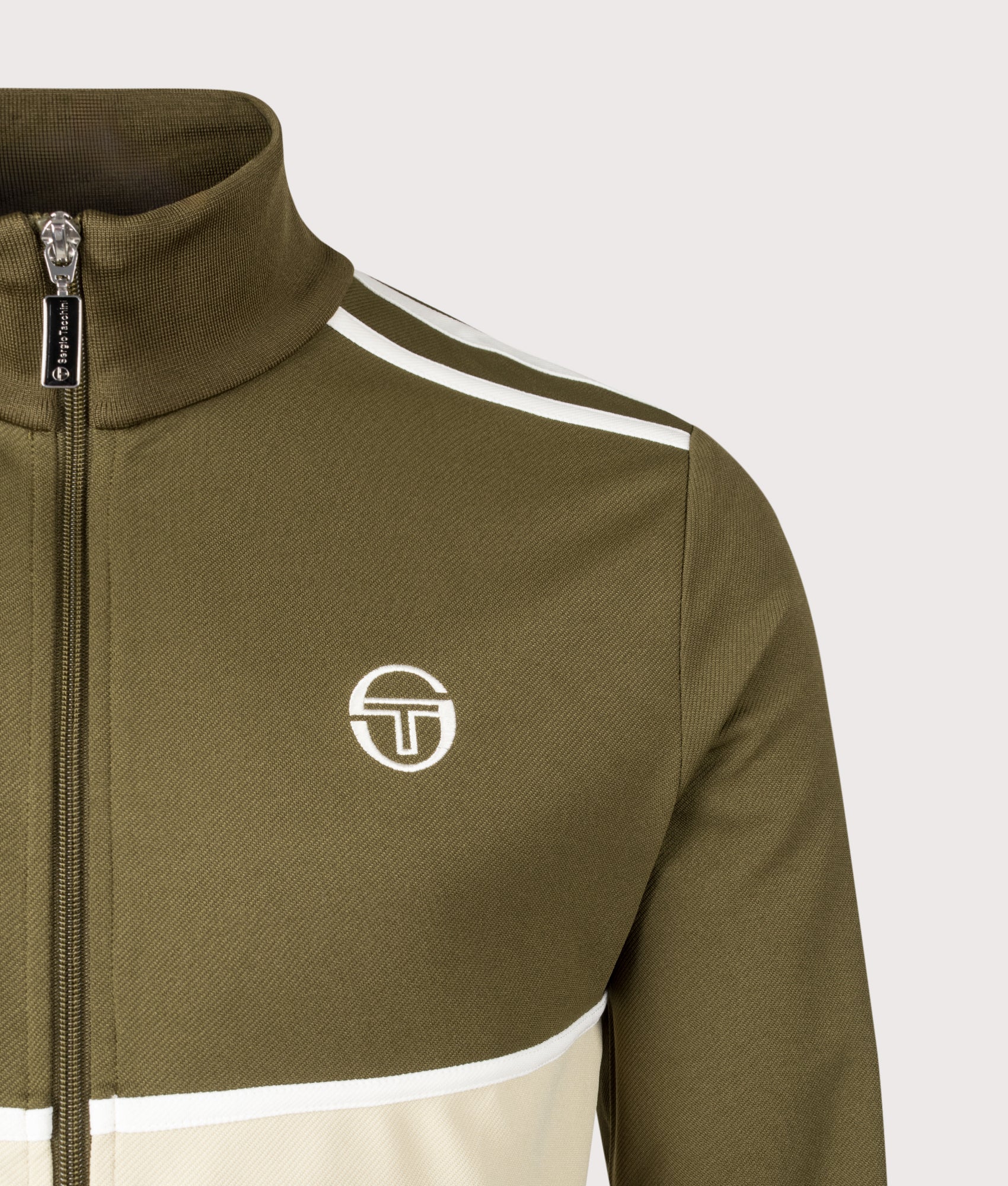 Sergio Tacchini Locchi Track Top in Dark Olive, Mojave Desert and Gardenia at EQVVS Menswear. Detail shot.
