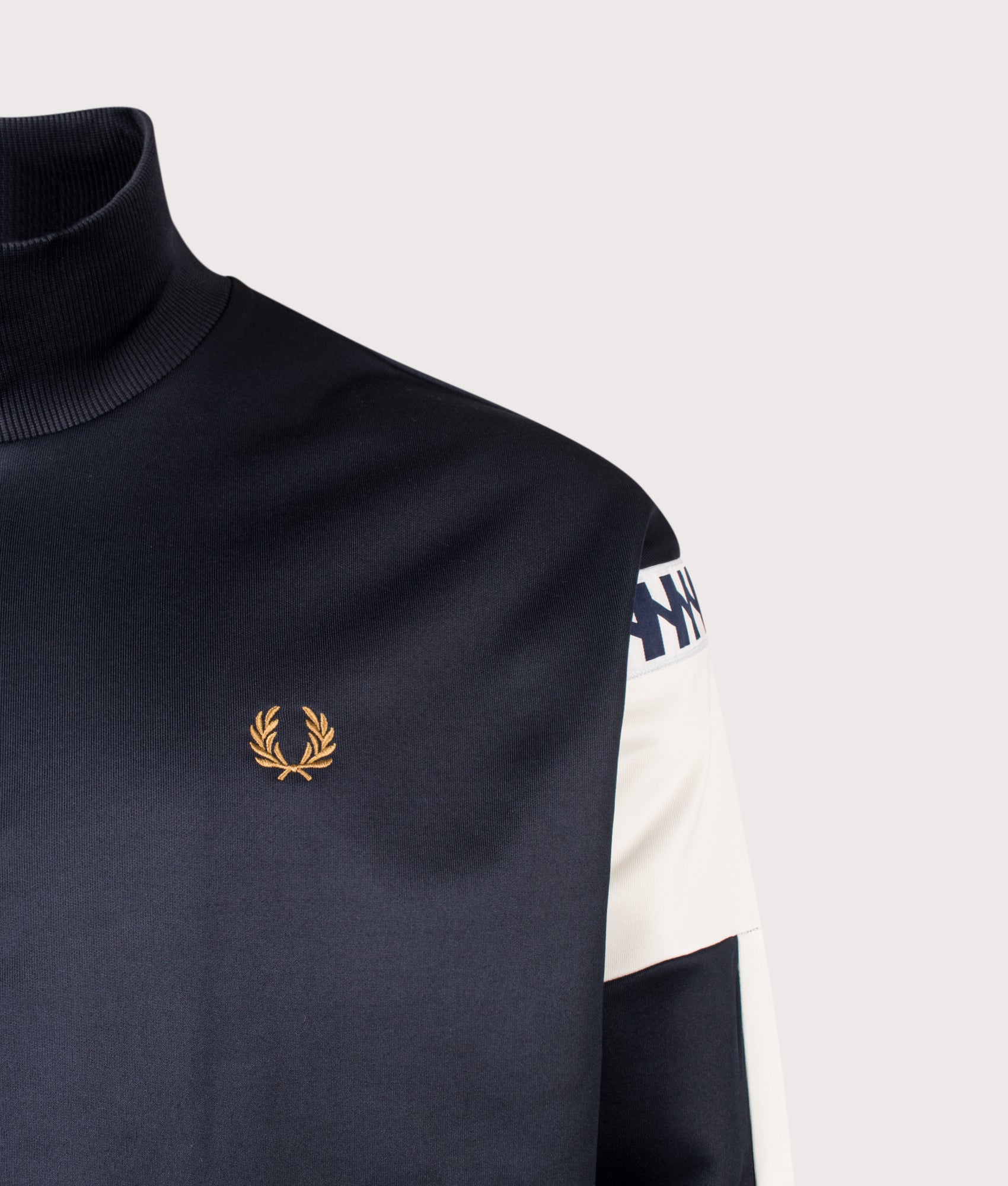 Meyba Cut And Sew Track Jacket in Navy by Fred Perry. Shot by EQVVS. Logo Detail shot.