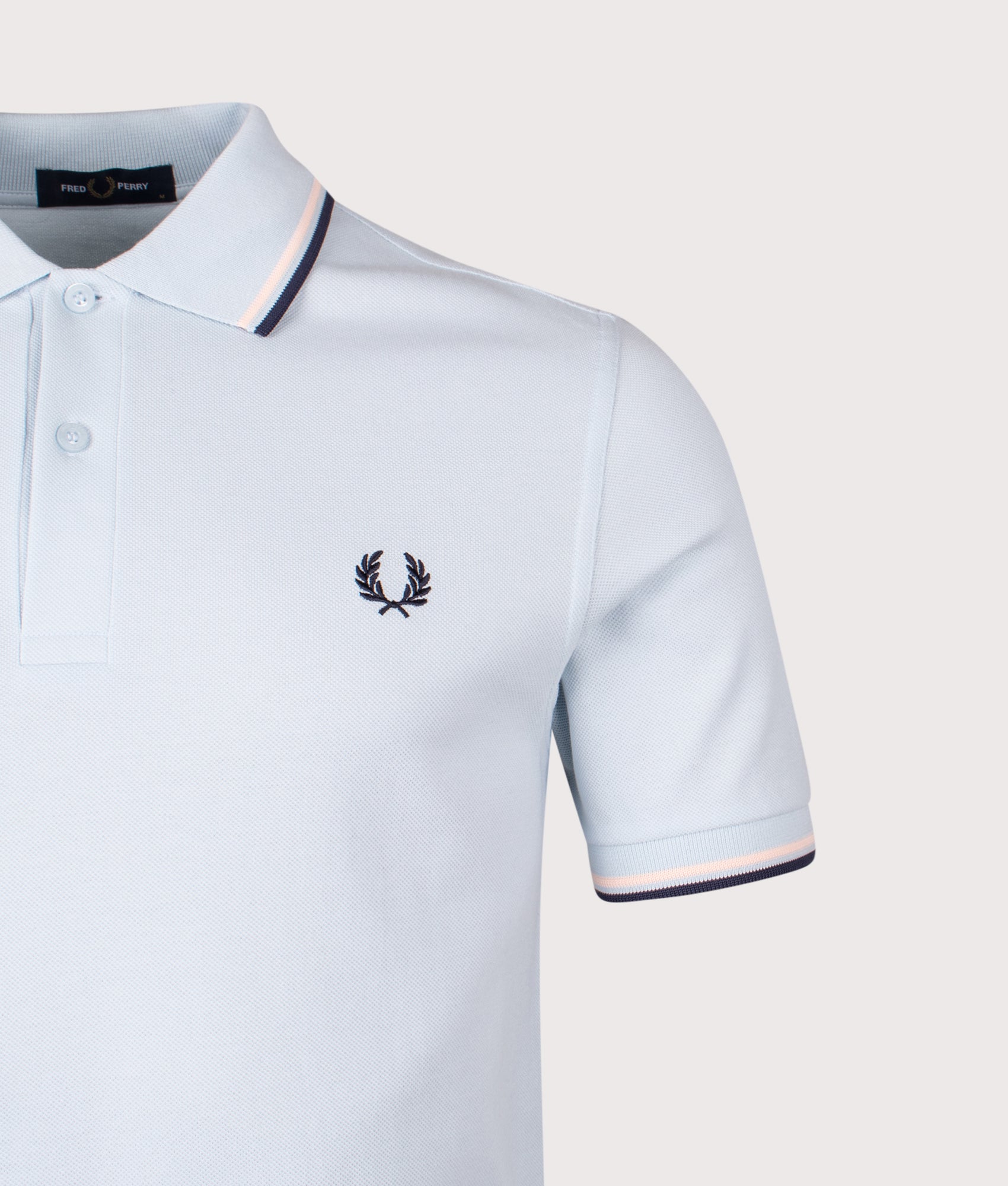 Fred Perry Twin Tipped Polo Shirt in Light Ice/Silky Peach/Tennis Blue at EQVVS Menswear. Detail Shot.