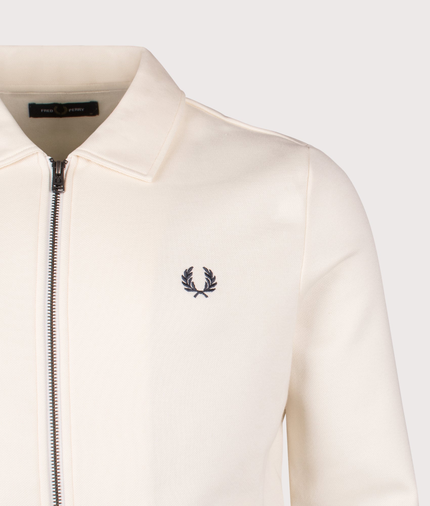 Fred Perry Zip Through Collared Sweatshirt in Ecru at EQVVS Menswear. Detail shot.