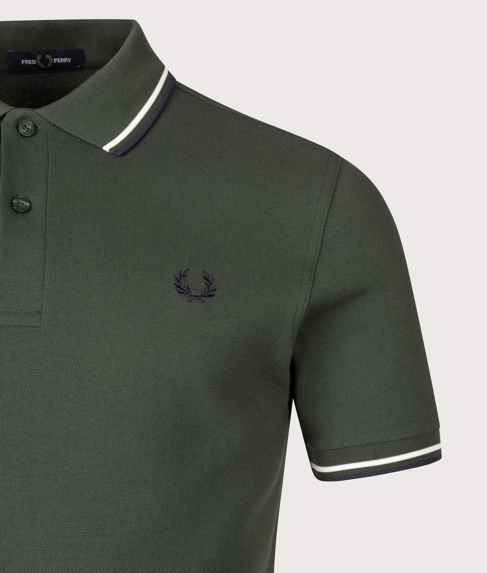 Fred Perry Twin Tipped Fred Perry Polo Shirt in Court Green, Snow White and Navy at EQVVS Menswear. Detail shot.