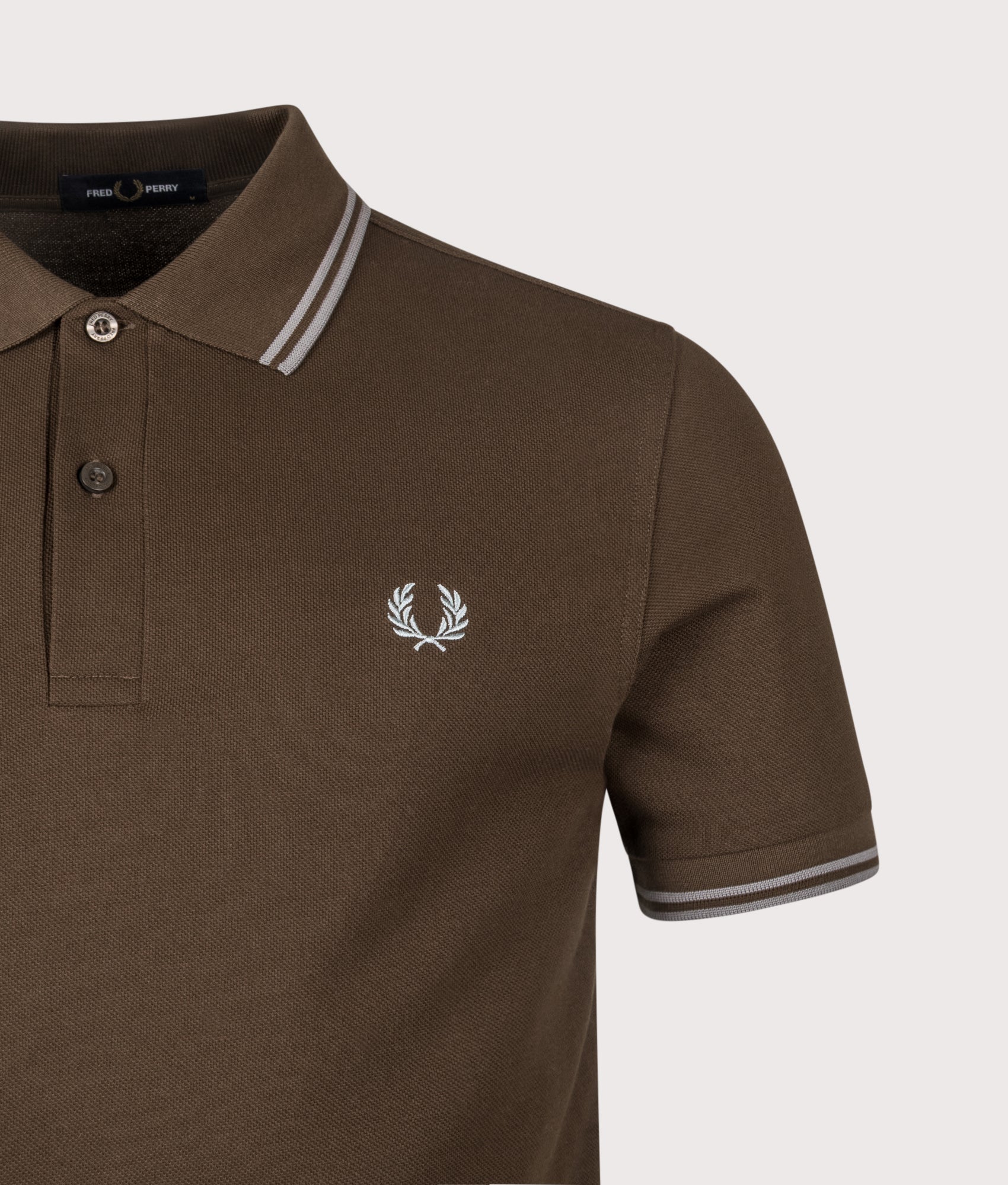Fred Perry Twin Tipped  Polo Shirt arrives in the Burnt Tobacco and Stockport Blue at EQVVS Menswear. Detail shot.