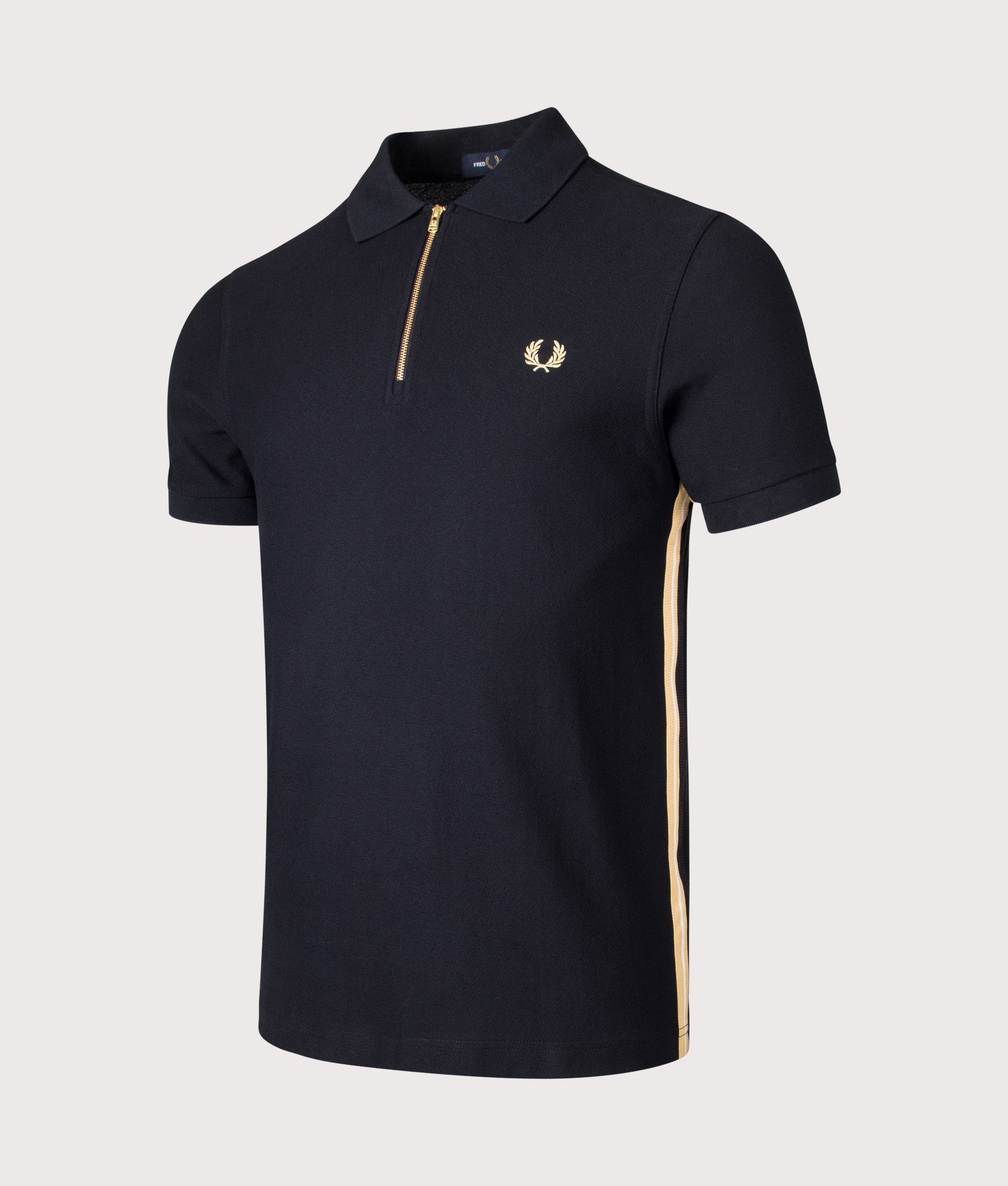 Fred Perry Stripe Tape Zip Neck Polo Shirt in Black and Champagne at EQVVS Menswear. Angled front shot.