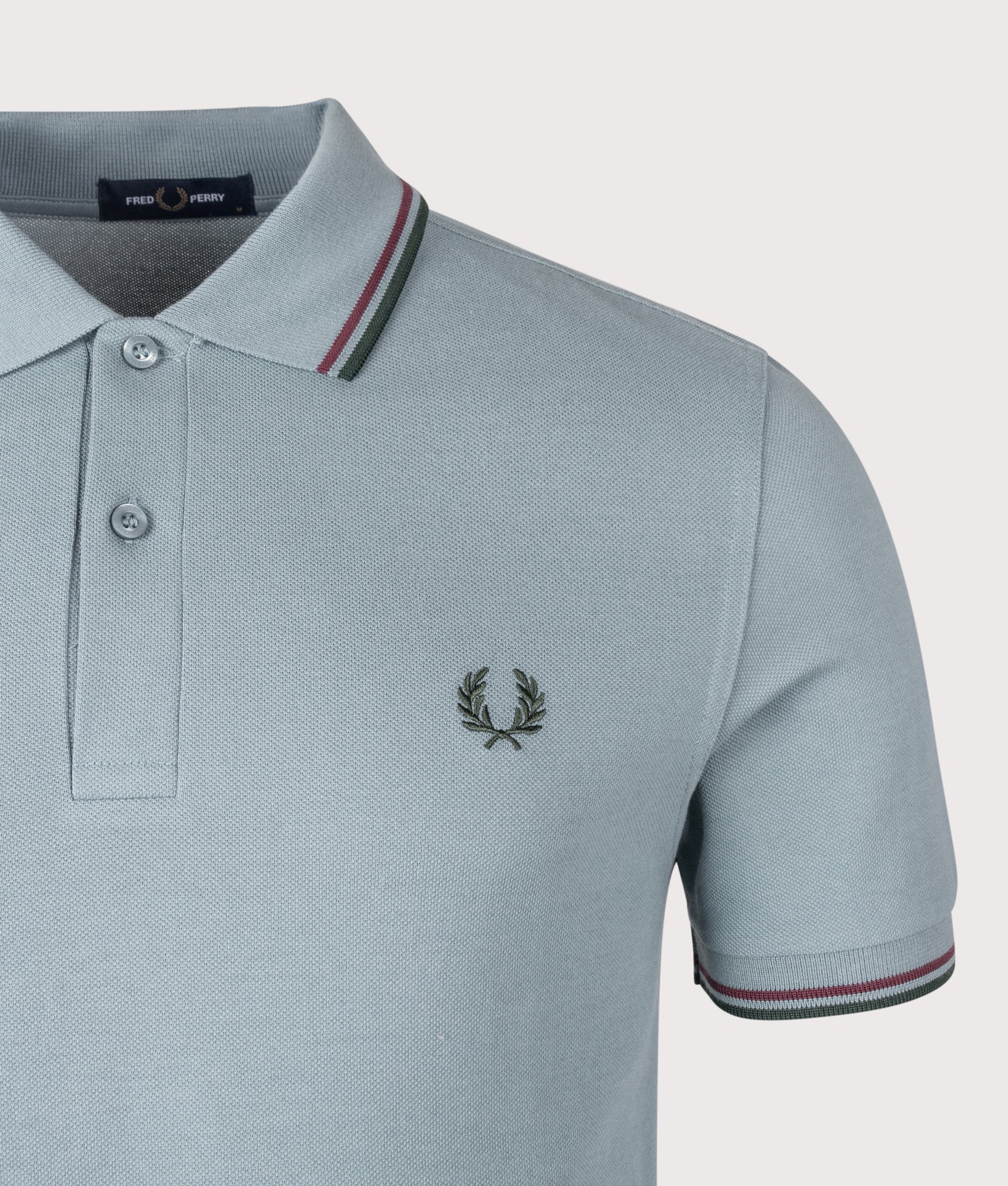 Fred Perry Twin Tipped Fred Perry Polo Shirt in Stockport Blue, Oxblood and Grassroots at EQVVS Menswear. Detail shot.