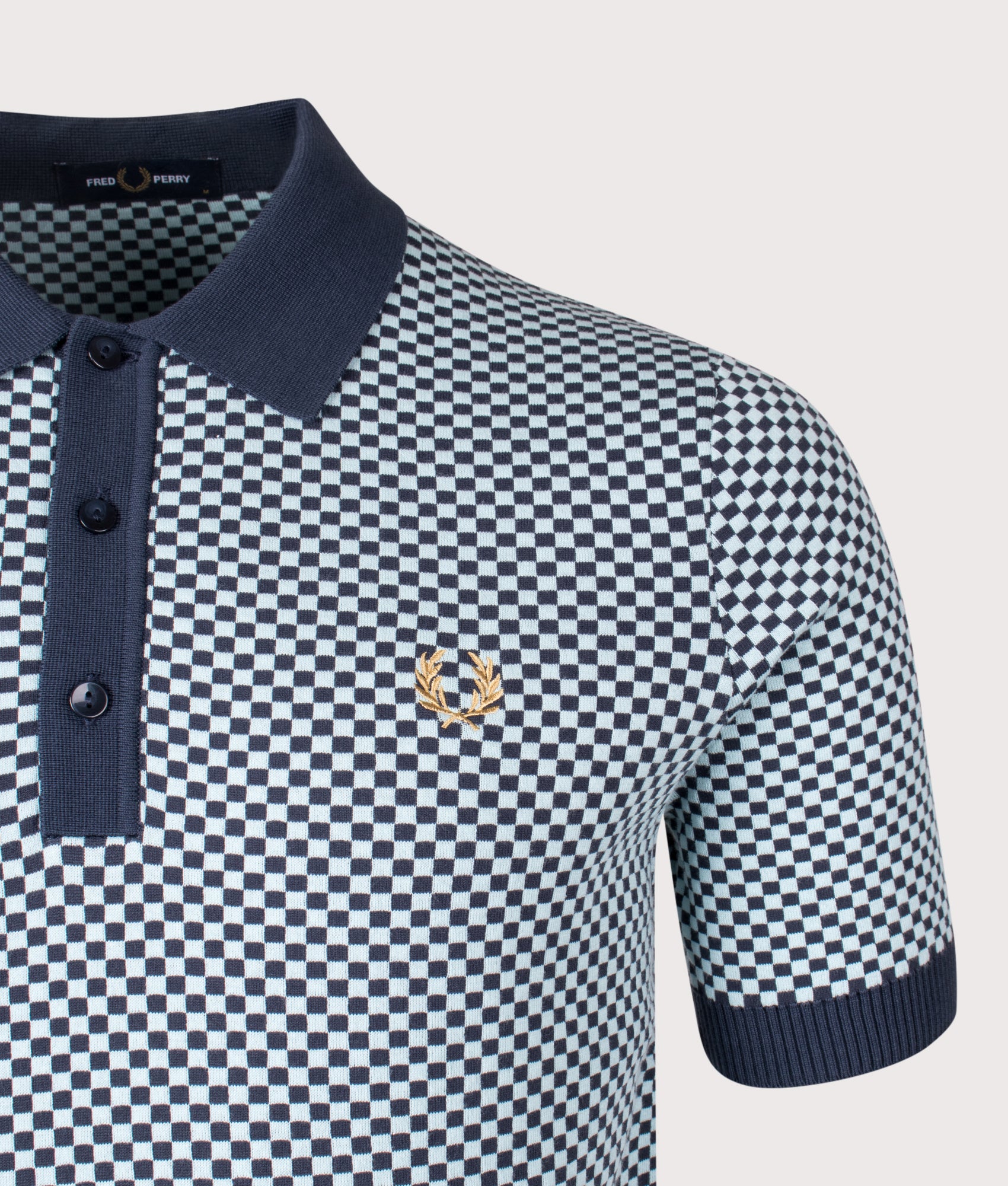Fred Perry Chequerboard Knitted Polo Shirt in Dark Airforce at EQVVS Menswear. Detail shot.