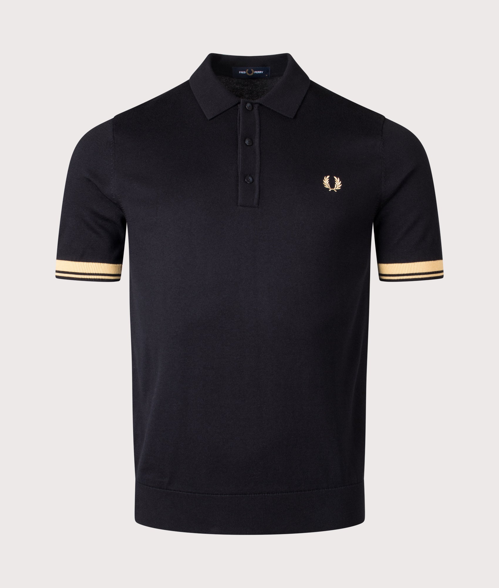 Fred Perry Contrast Cuff Knitted Polo Shirt in Black and Champagne at EQVVS Menswear. Front shot.