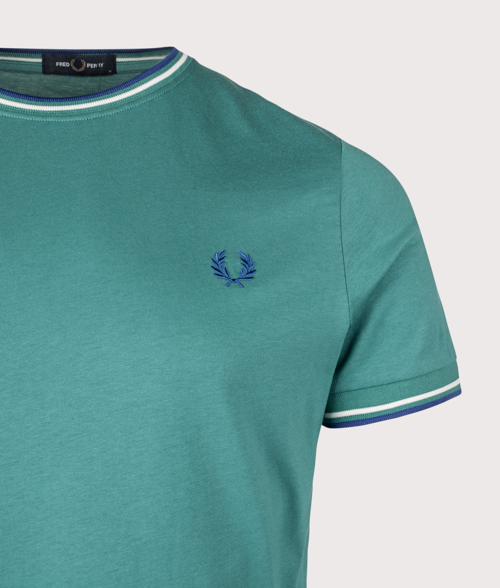 Fred Perry Twin Tipped T-Shirt in Deep Mint, Snow White and Soho Eclipse at EQVVS Menswear. Detail shot.