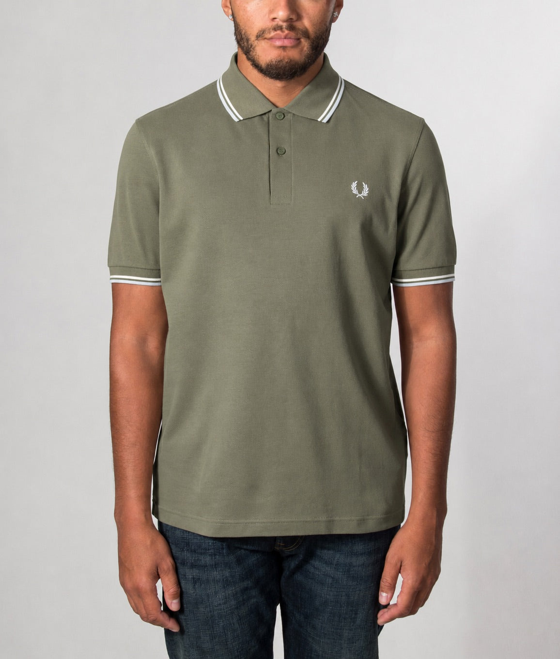 Fred Perry Twin Tipped Polo Shirt in Laurel Wreath Green, Ecru and Dusky Blue at EQVVS Menswear. Model front shot.