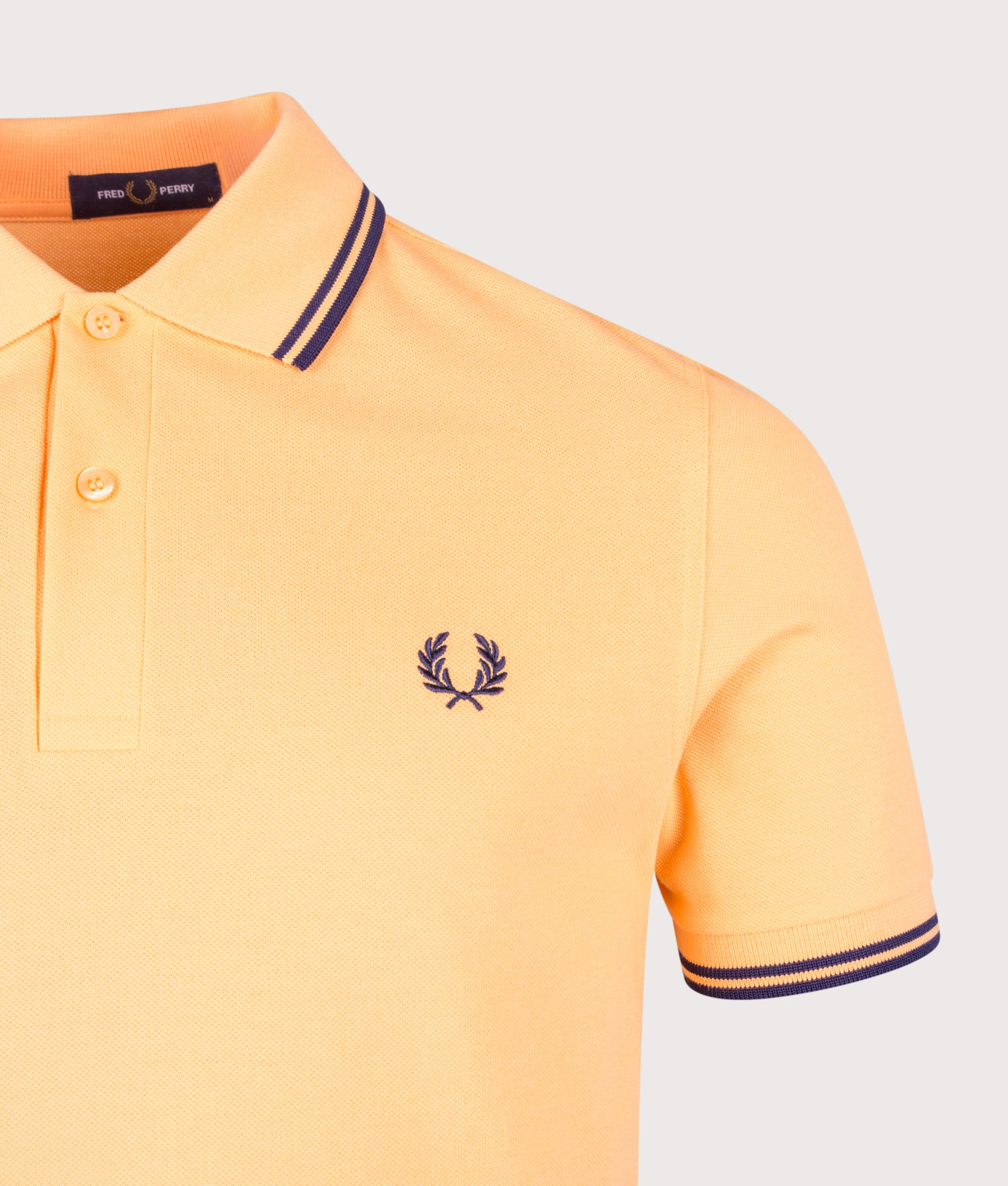 Fred Perry Twin Tipped Polo Shirt in Peach and French Navy at EQVVS Menswear. Detail shot.
