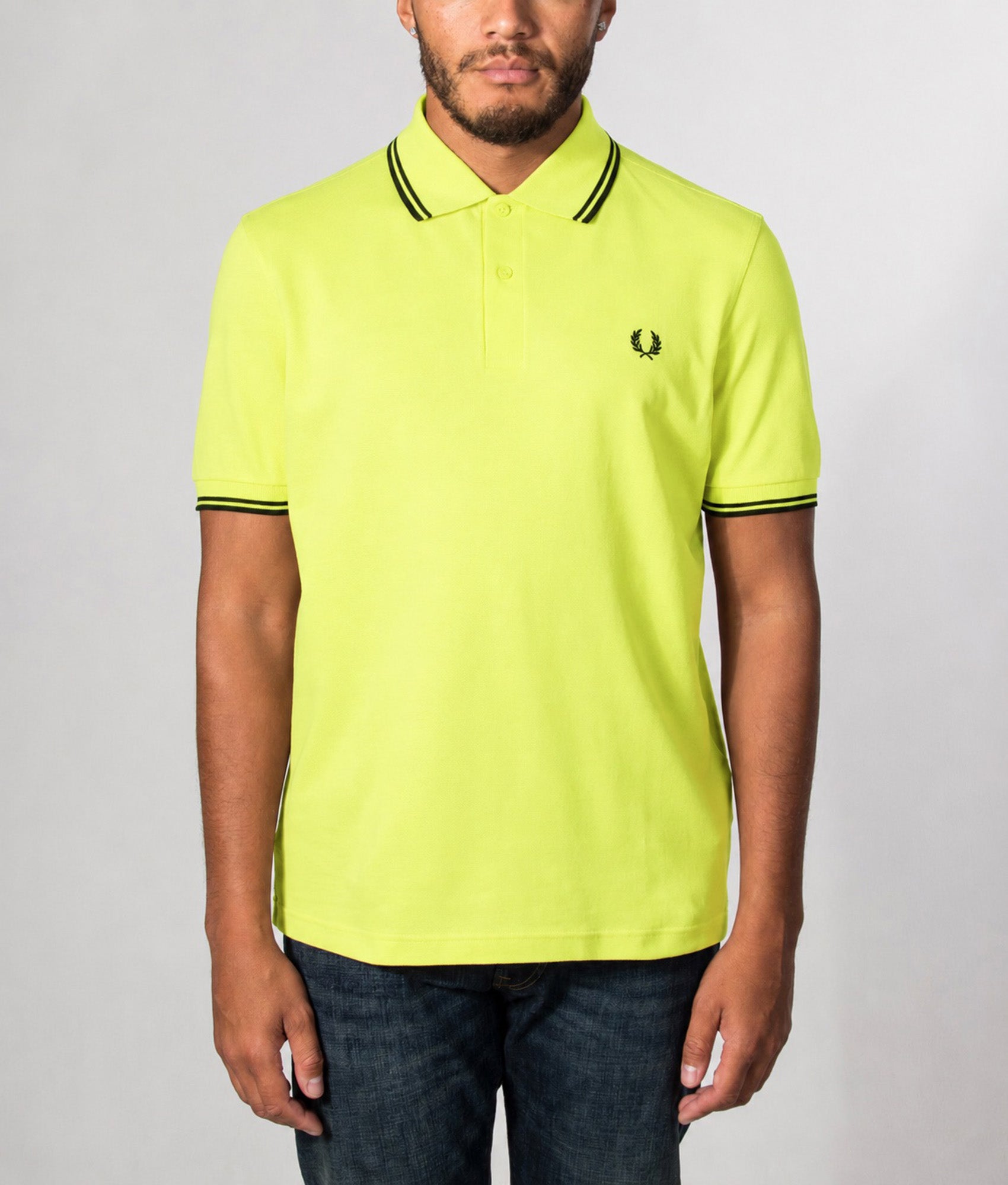 Fred Perry Twin Tipped Polo Shirt in Citron and Black at EQVVS Menswear. Model front shot.