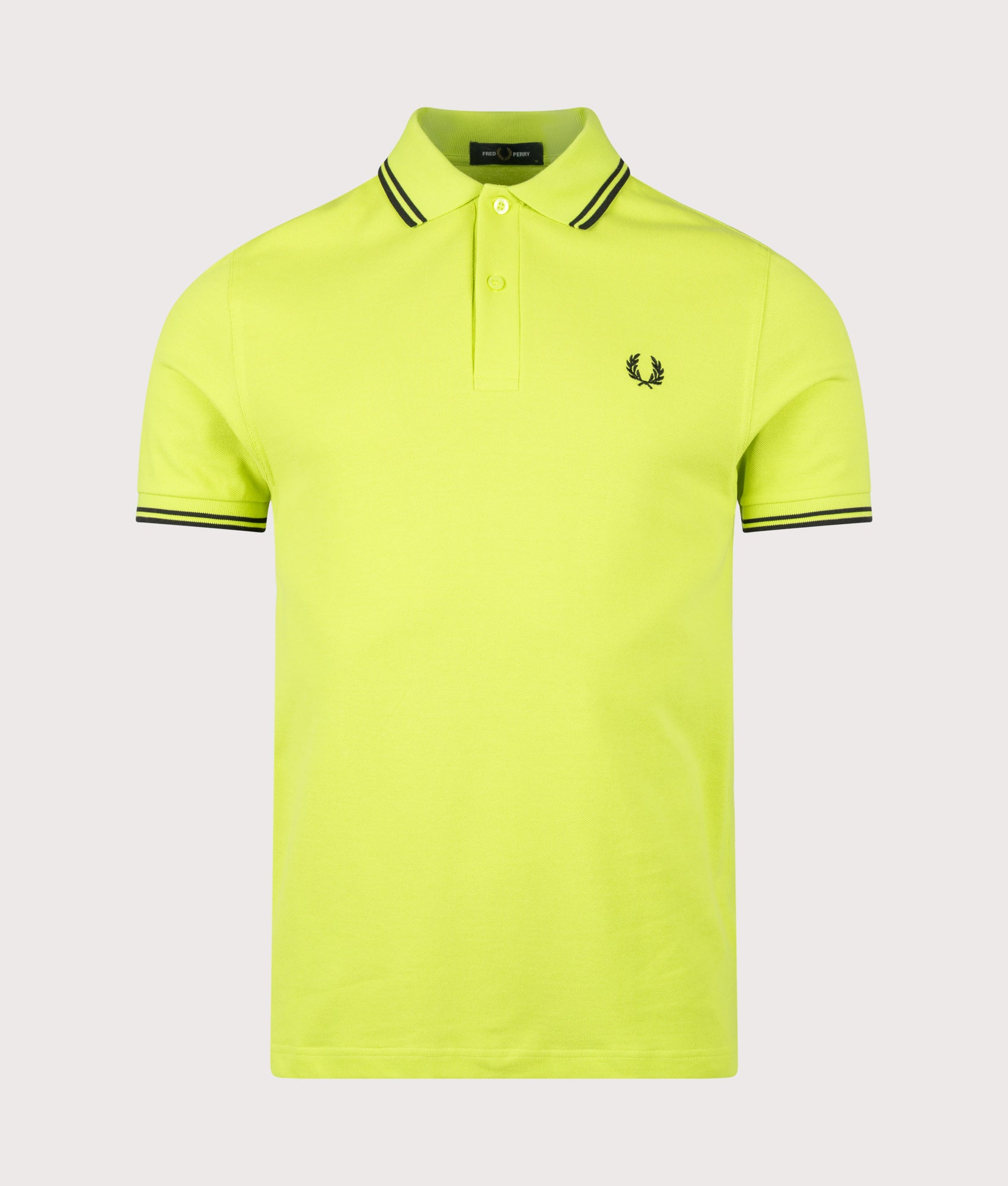 Fred Perry Twin Tipped Polo Shirt in Citron and Black at EQVVS Menswear. Front shot.