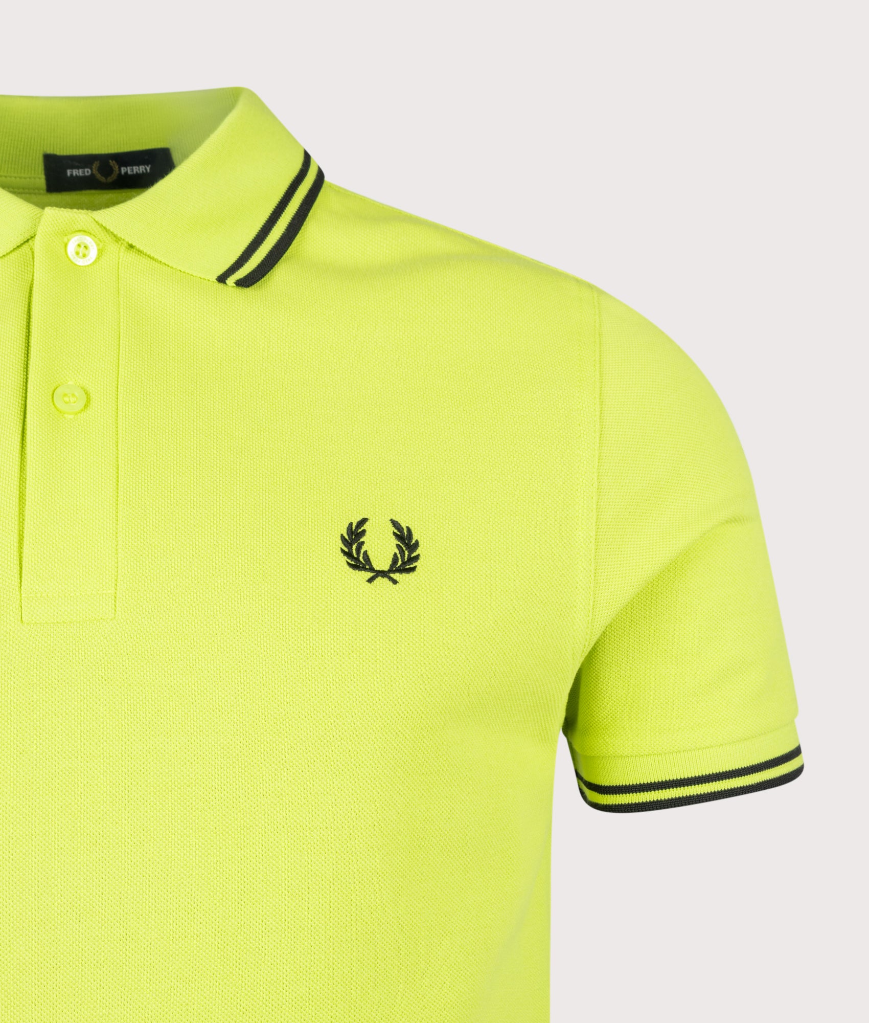 Fred Perry Twin Tipped Polo Shirt in Citron and Black at EQVVS Menswear. Detail shot.