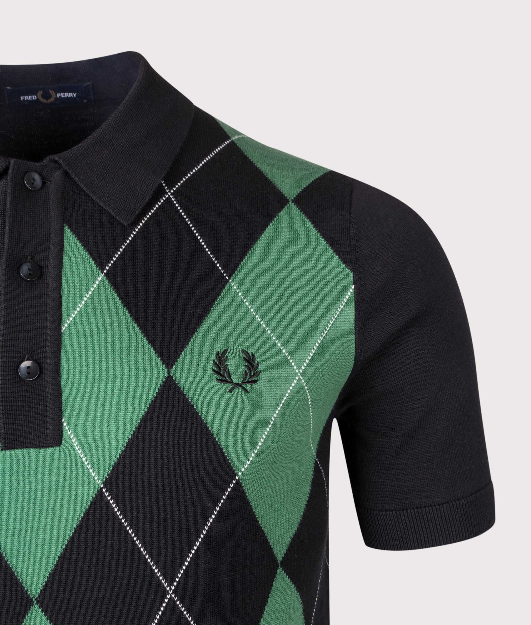 Fred Perry Argyle Knitted Polo Shirt in Black at EQVVS Menswear. Detail shot.
