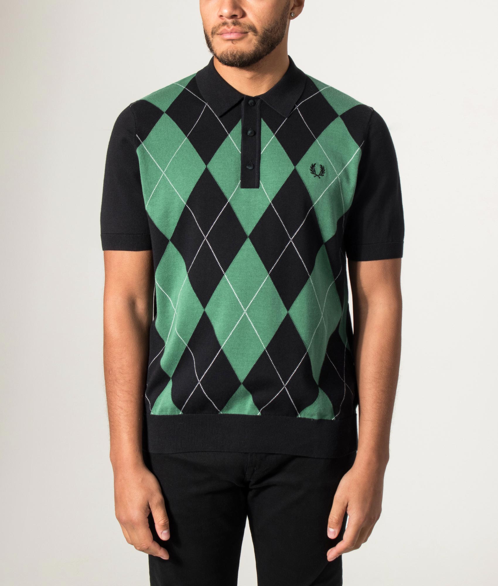 Fred Perry Argyle Knitted Polo Shirt in Black at EQVVS Menswear. Model front shot.