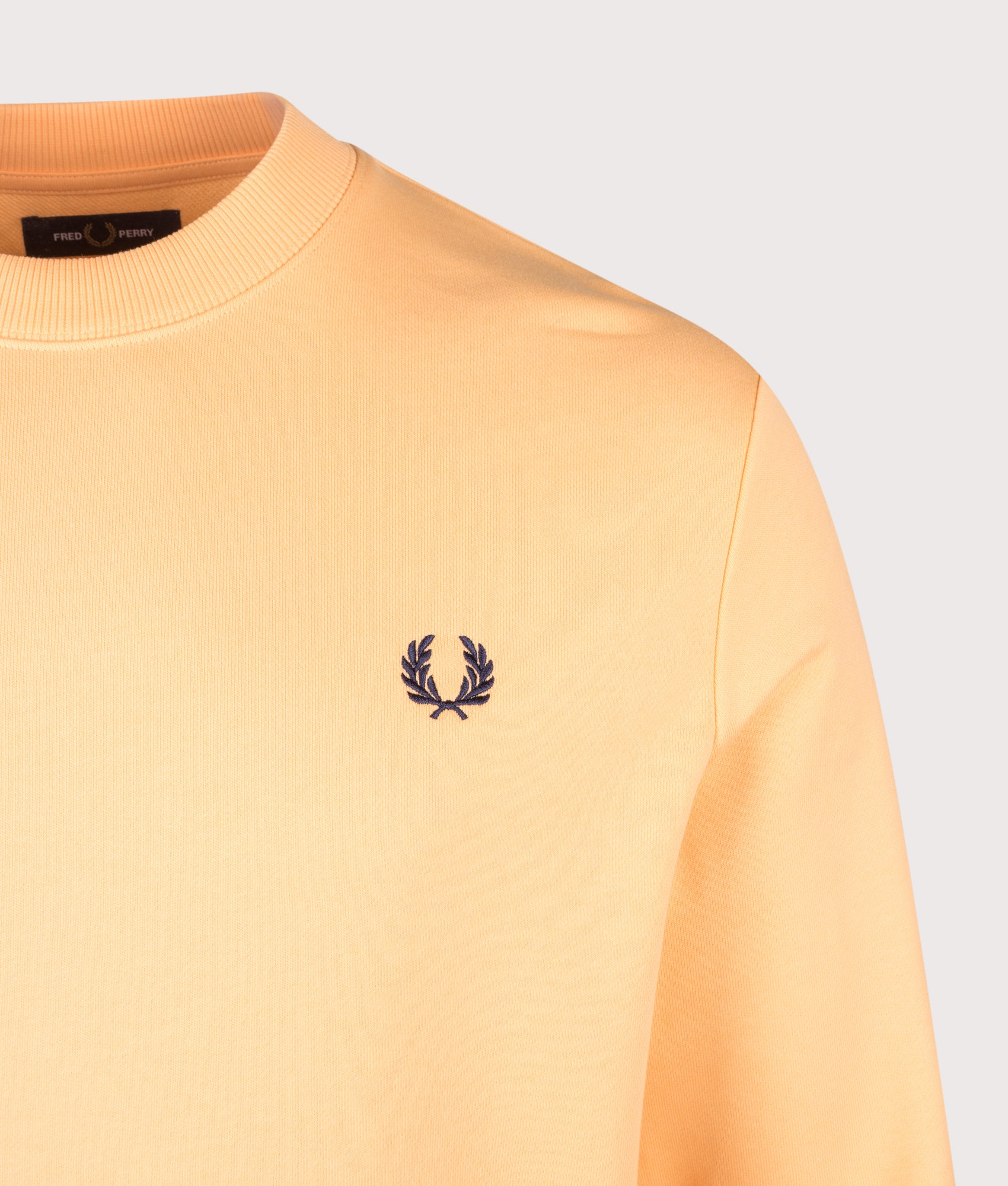 Fred Perry Crew Neck Sweatshirt in Peach, Citron and French Navy at EQVVS Menswear. Detail shot.