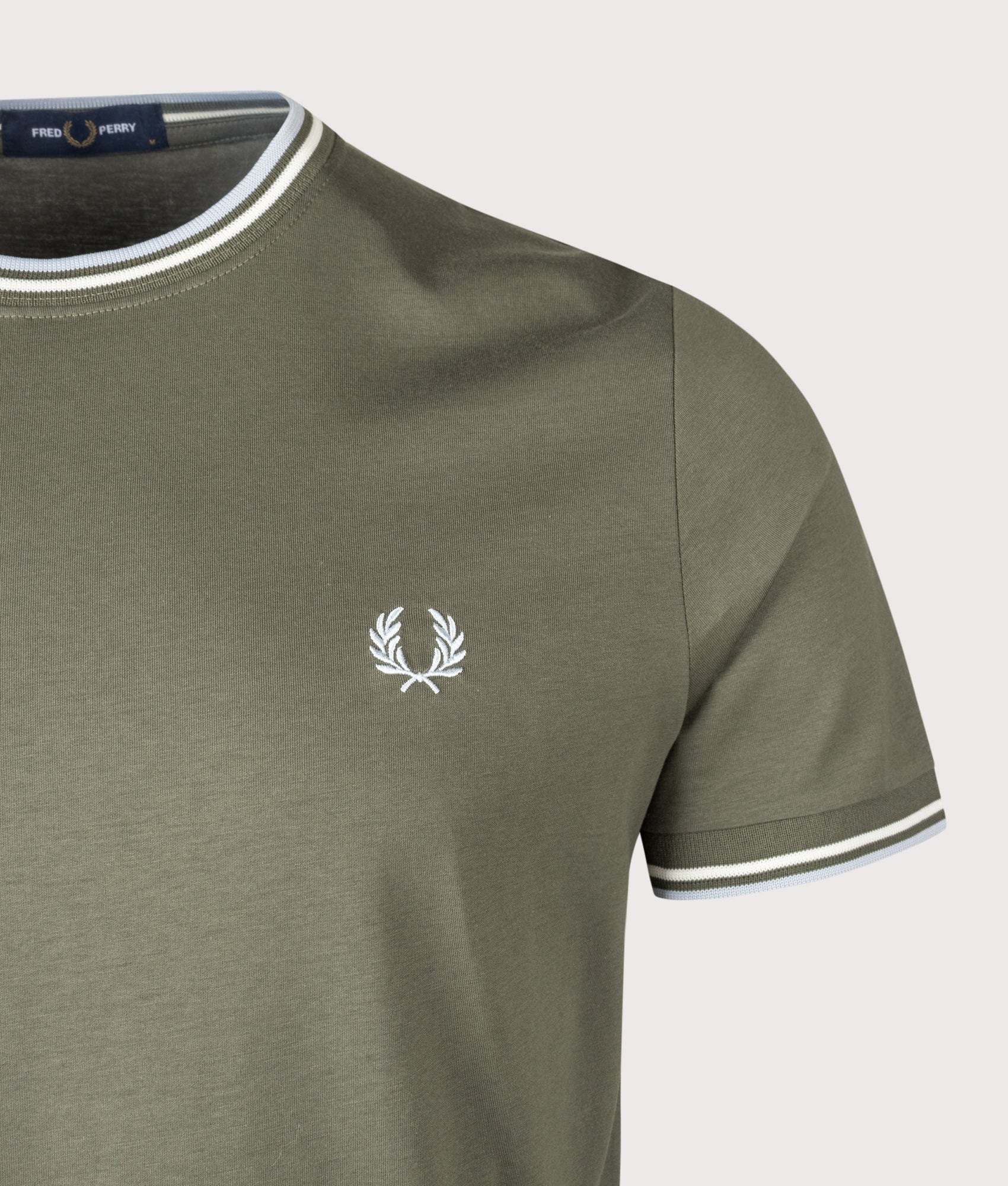 Fred Perry Twin Tipped T-Shirt in Laurel Wreath Green, Ecru and Dusky Blue at EQVVS Menswear. Detail shot.