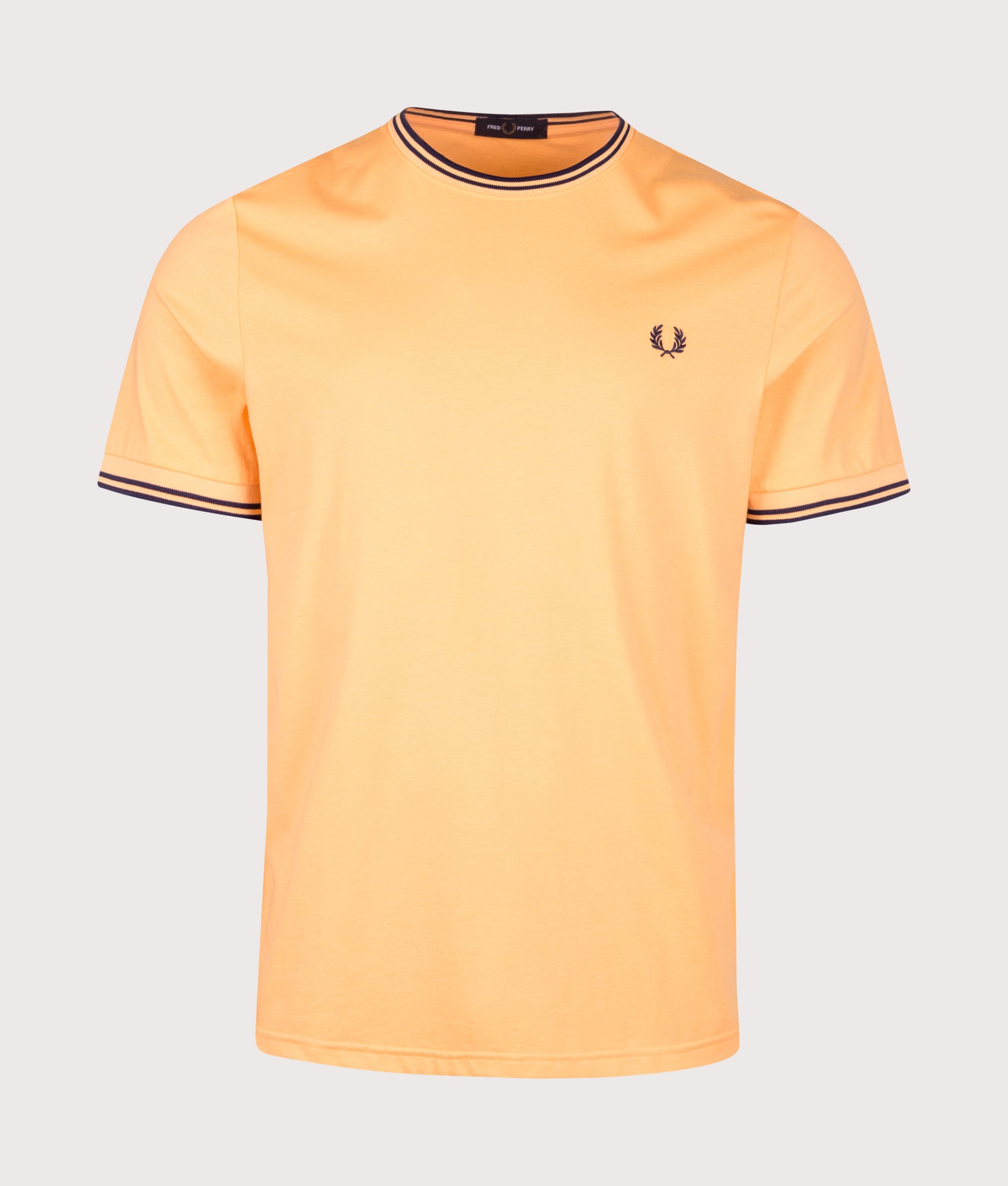 Fred Perry Regular Fit Twin Tipped T-Shirt in Peach and French Navy at EQVVS Menswear. Front shot.