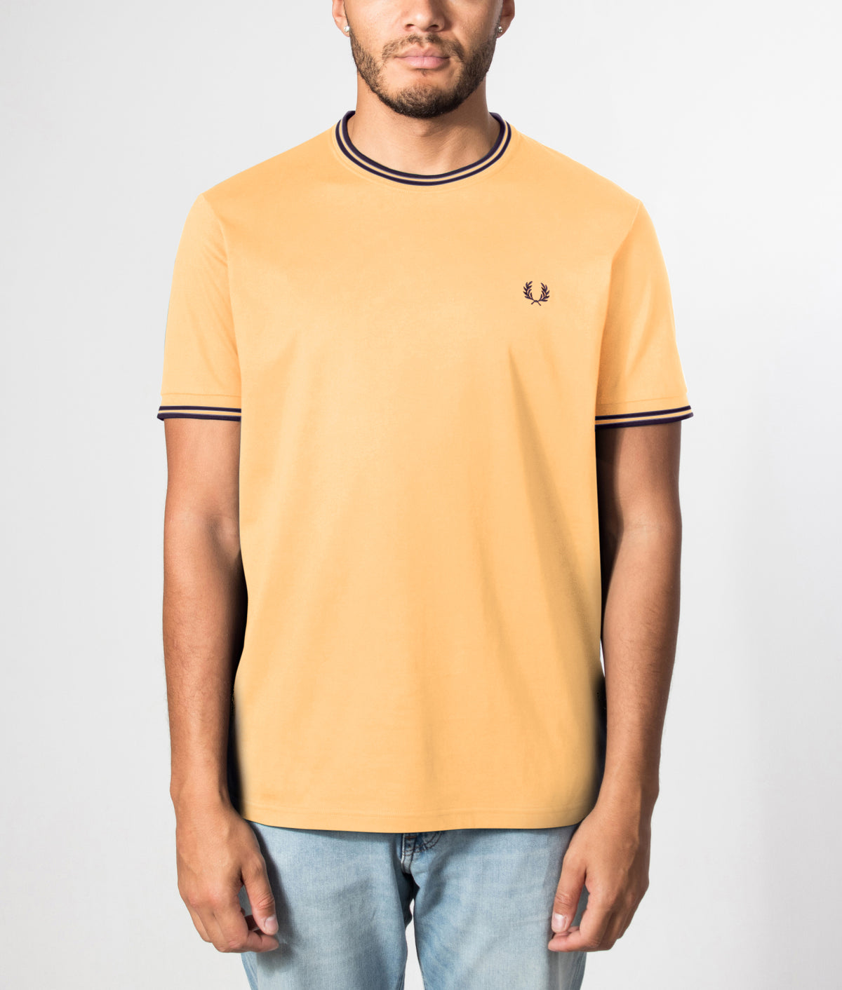 Fred Perry Regular Fit Twin Tipped T-Shirt in Peach and French Navy at EQVVS Menswear. Front model shot.  