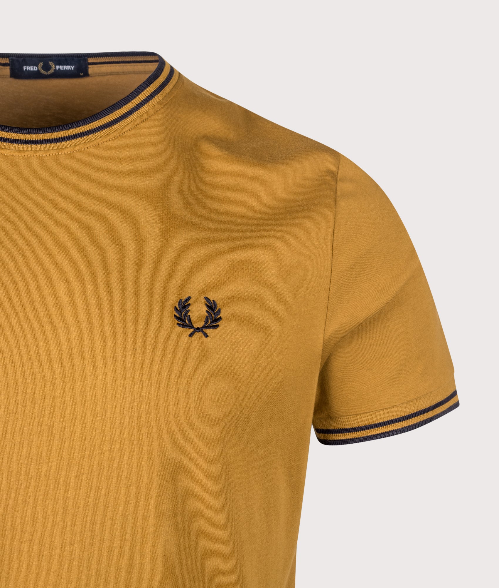 Fred Perry Twin Tipped T-Shirt in Dark Caramel and Navy at EQVVS Menswear. Detail shot.