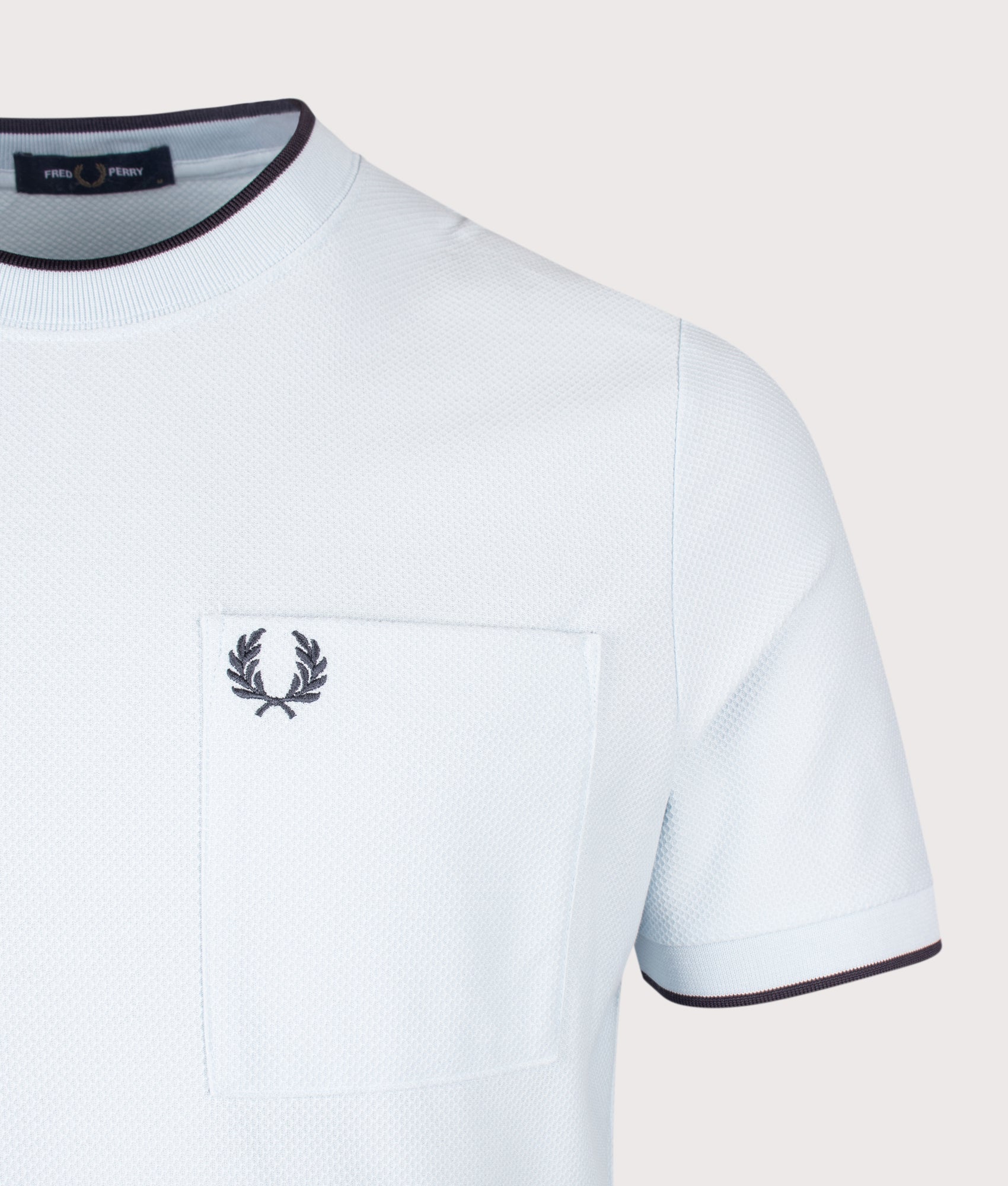 Fred Perry Pocket Detail Piqué T-Shirt in Light Ice at EQVVS Menswear. Detail shot.
