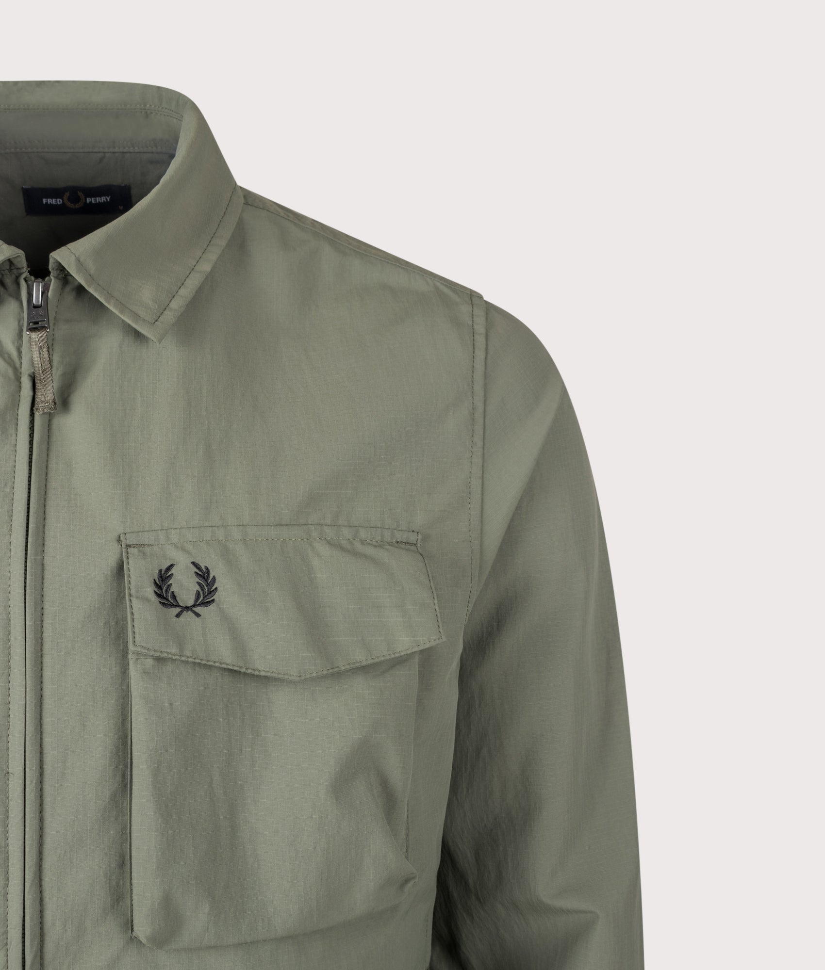 Fred Perry Ripstop Pocket Overshirt in Laurel Wreath Green at EQVVS Menswear. Detail shot.