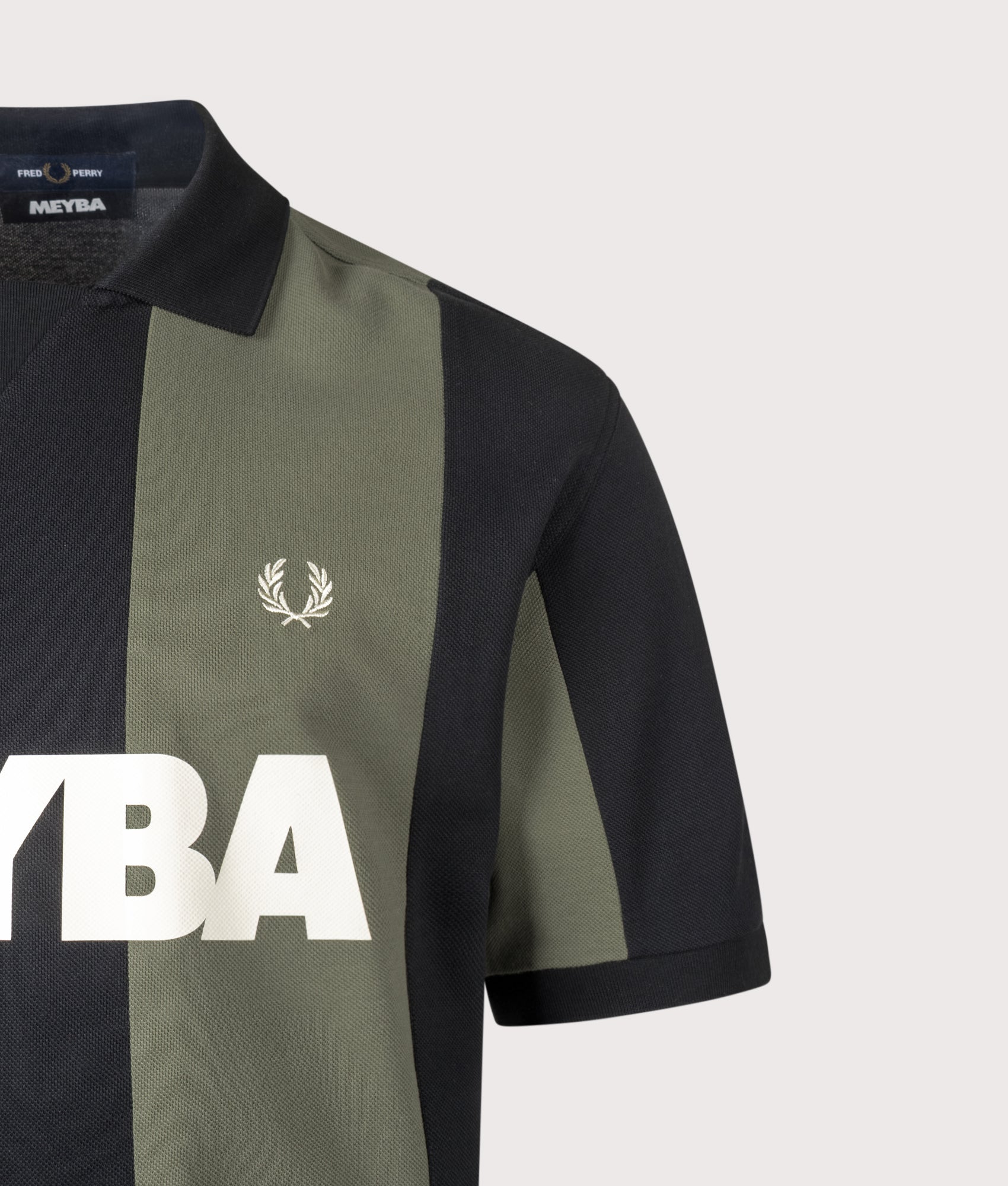 Meyba Cut And Sew Polo Shirt in Black by Fred Perry. Shot by EQVVS. Logo detail shot.