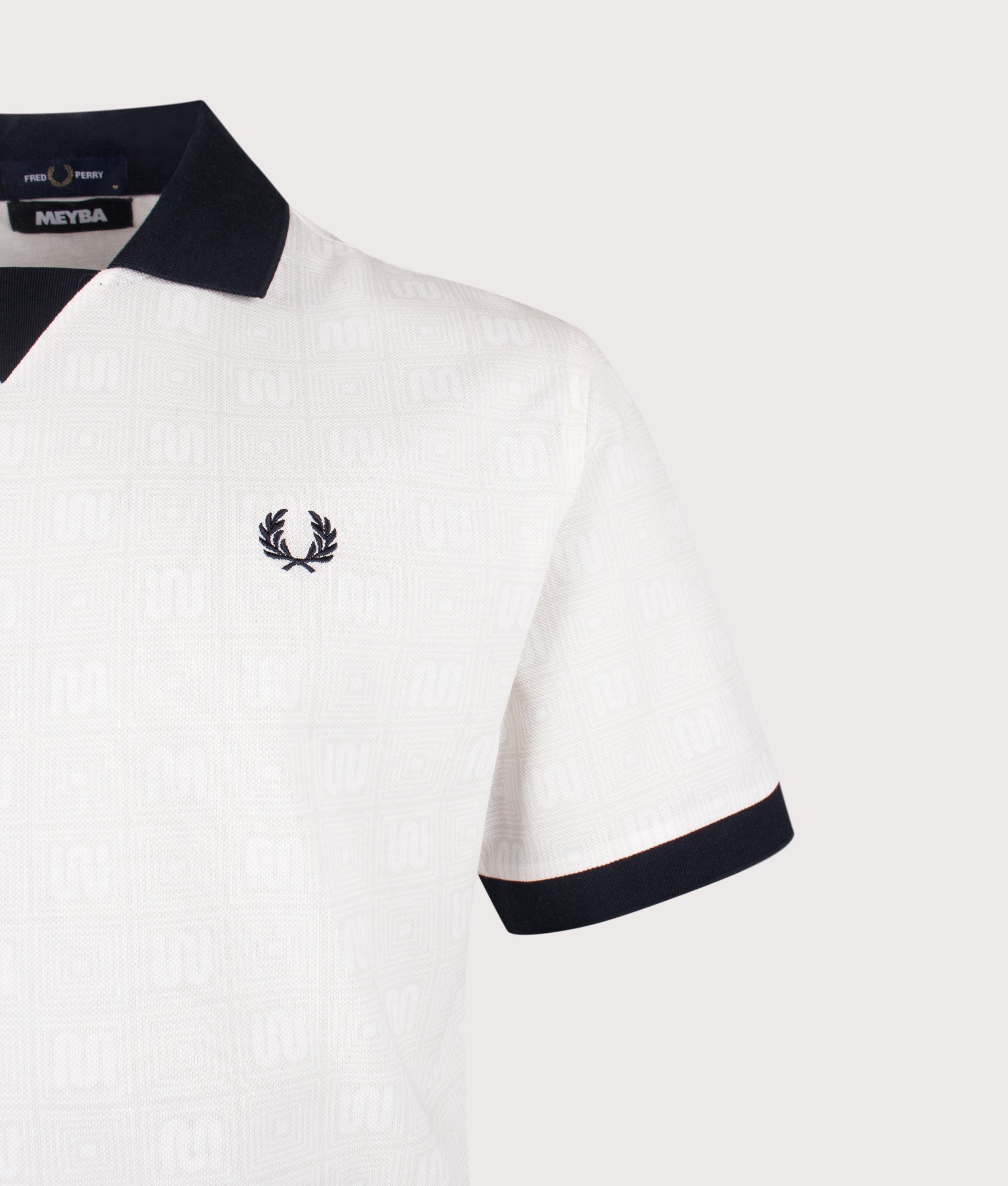 Meyba Printed Polo Shirt in Ecru by Fred Perry. Shot by EQVVS. Logo detail shot.