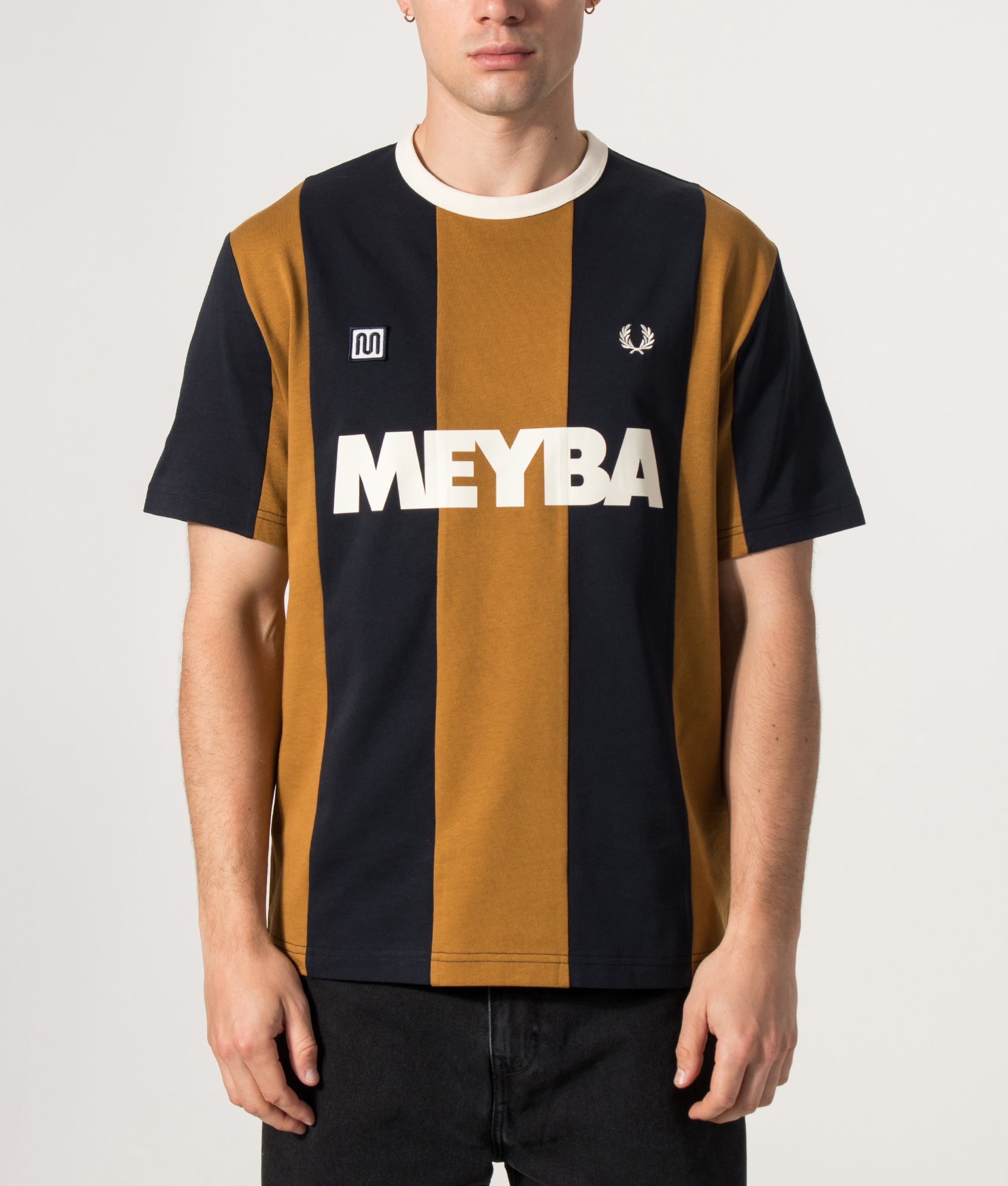 Fred Perry x Meyba Relaxed Fit Cut And Sew T-Shirt in Dark Caramel at EQVVS Menswear. Model front shot.