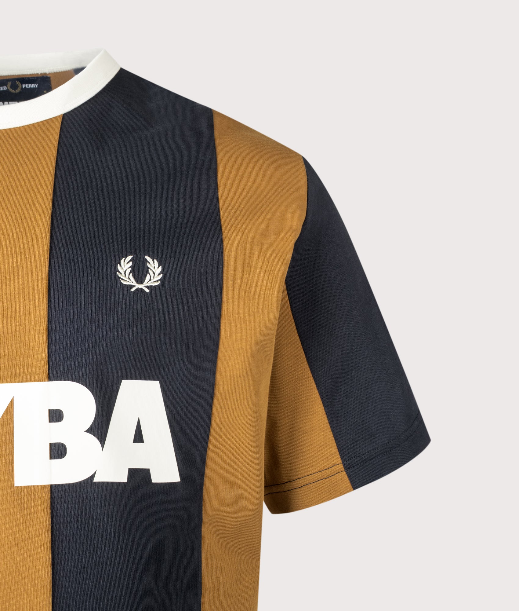 Meyba Cut And Sew T-Shirt in Dark Caramel by Fred Perry. Shot by EQVVS. Logo detail shot.