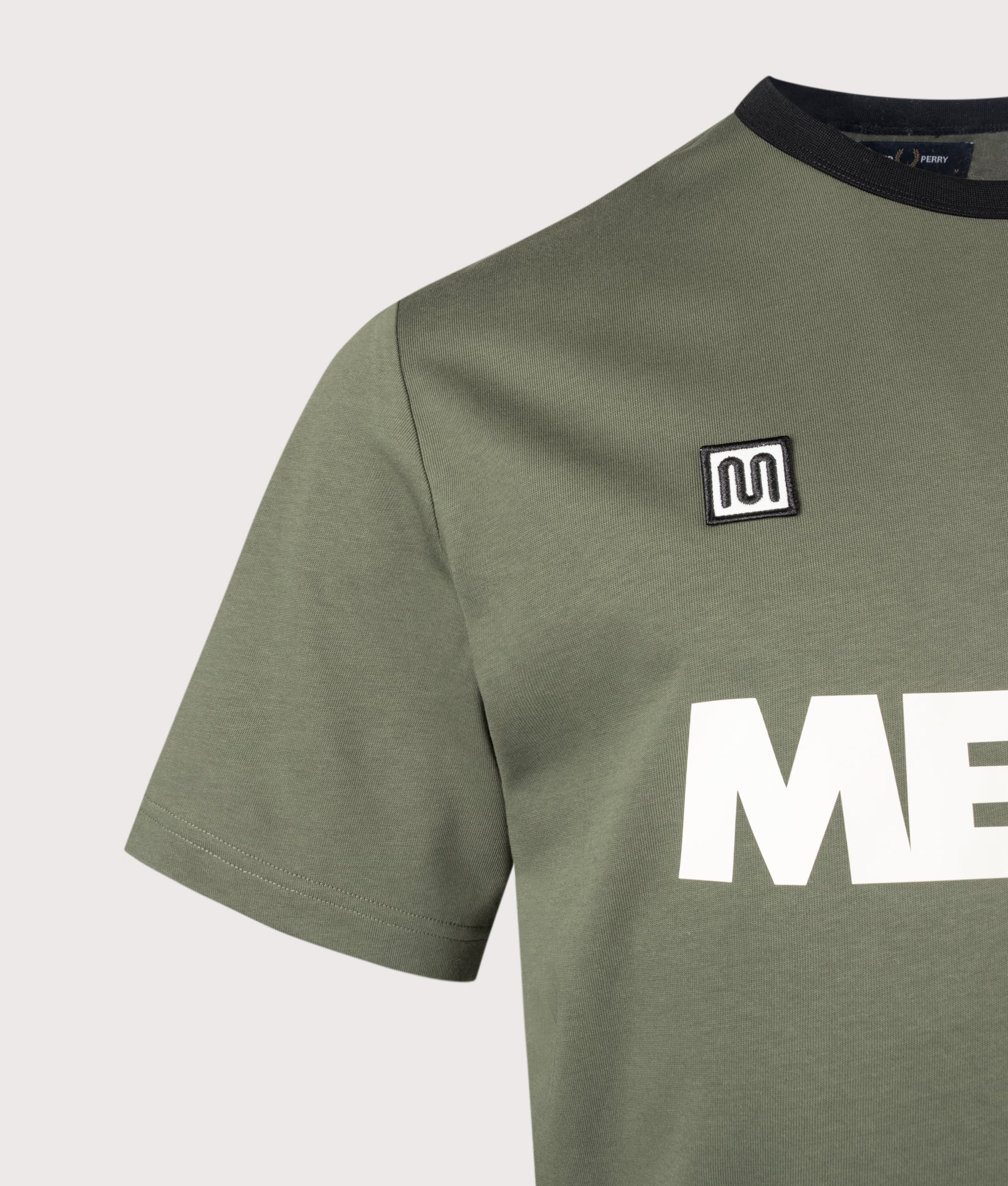 Meyba Ringer T-Shirt in Laurel Wreath Green by Fred Perry. Shot by EQVVS. Detail shot.