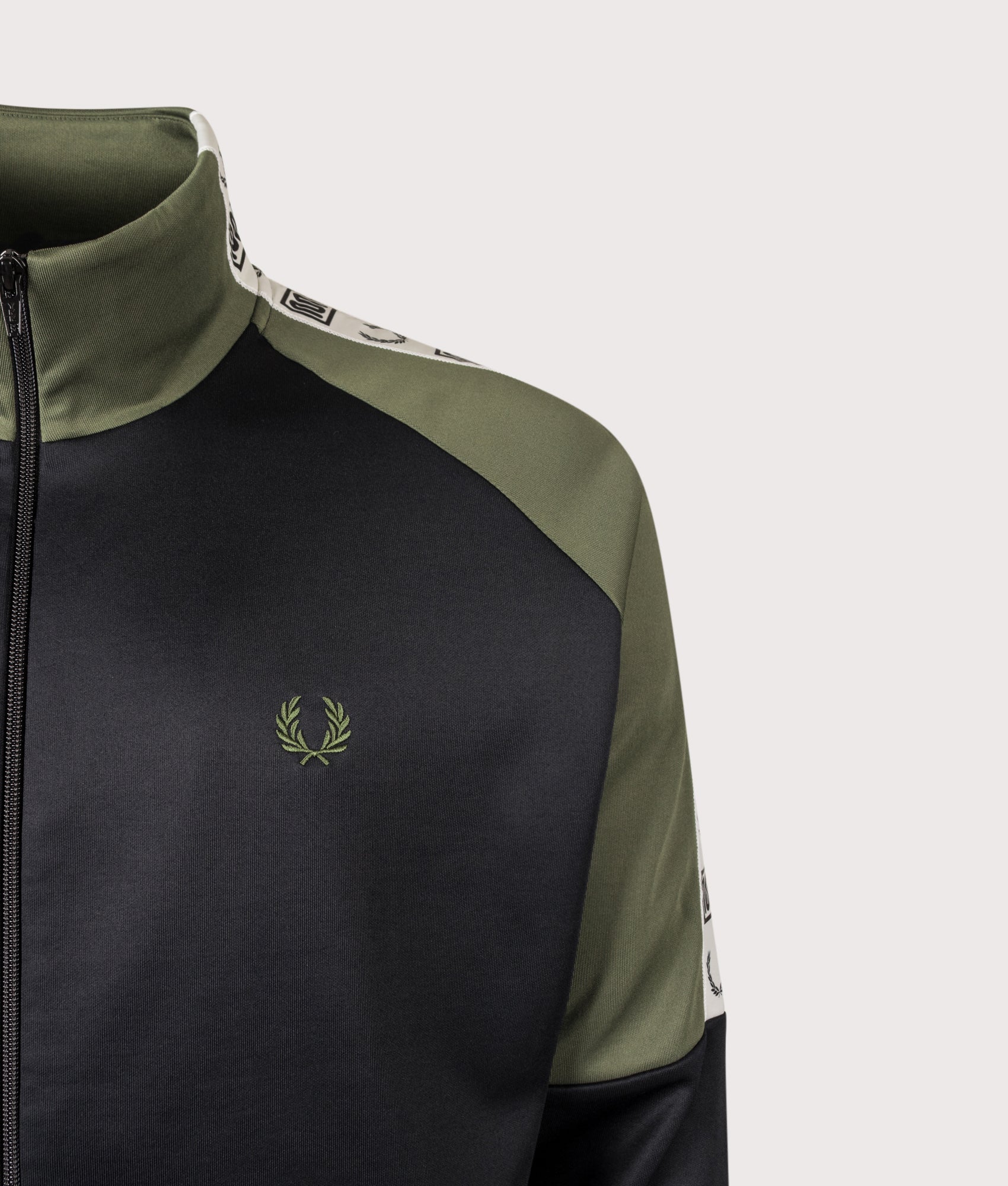 Meyba Taped Raglan Track Jacket in Black by Fred Perry. Shot by EQVVS. Logo detail shot.