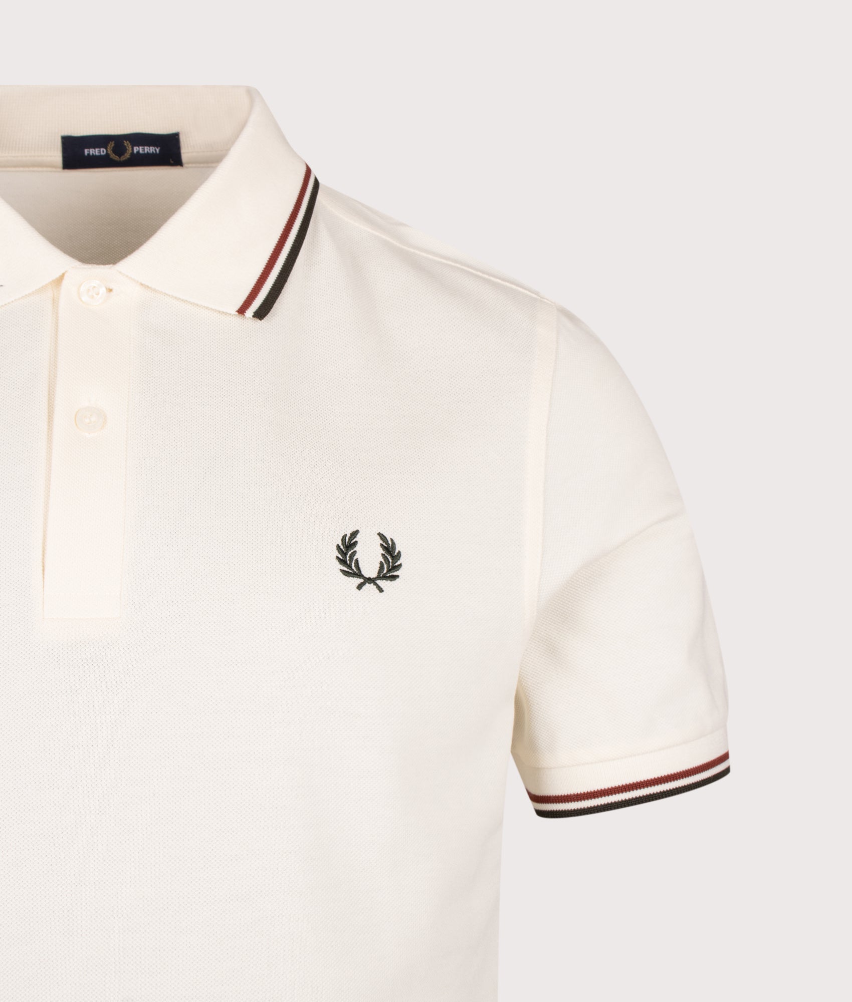 Fred Perry Twin Tipped Polo Shirt in Ecru, Brandy and Night Green at EQVVS Menswear. Detail shot.