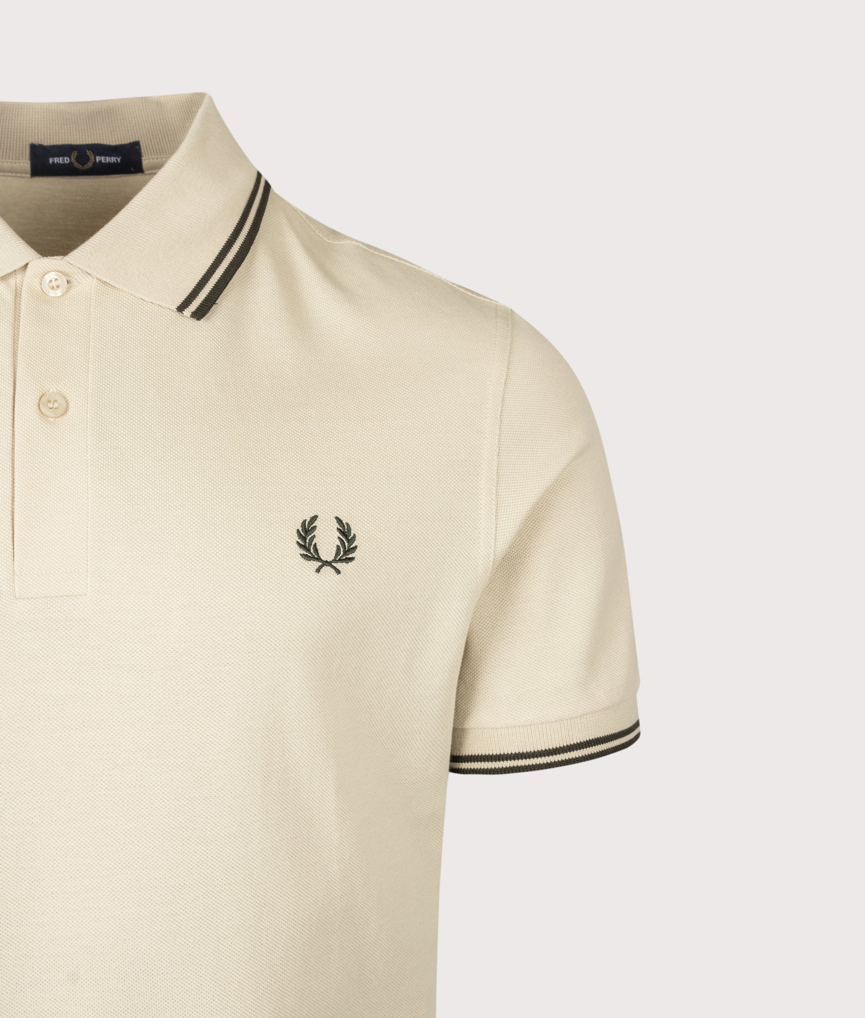 Fred Perry Twin Tipped Polo Shirt in Oatmeal and Night Green at EQVVS Menswear. Detail shot.