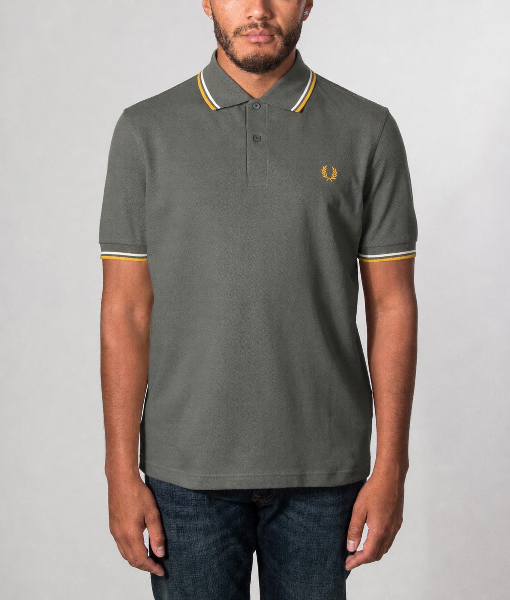 Fred Perry Twin Tipped Polo Shirt in Field Green, Ecru and Golden at EQVVS Menswear. Model front shot.