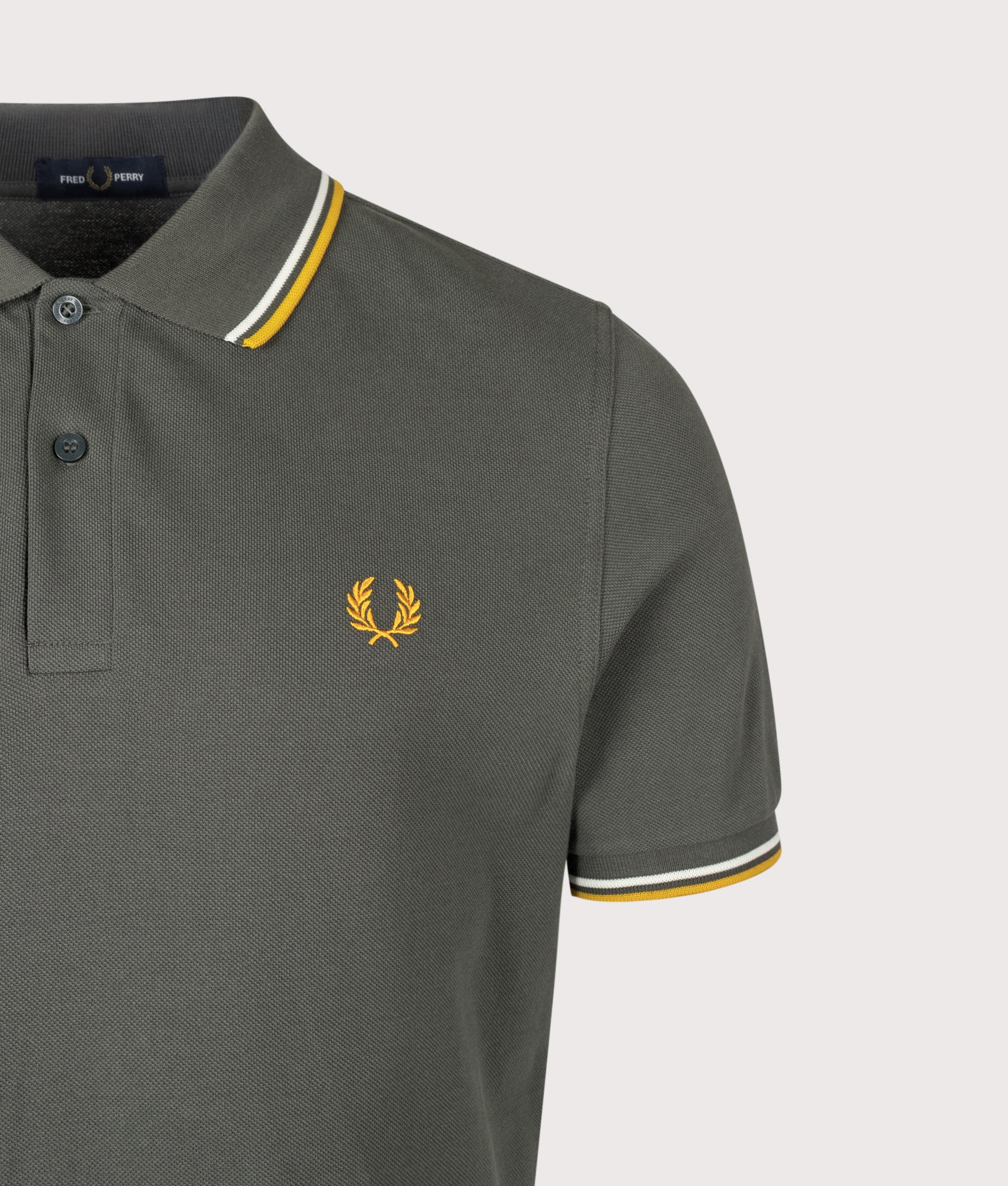 Fred Perry Twin Tipped Polo Shirt in Field Green, Ecru and Golden at EQVVS Menswear. Detail shot.