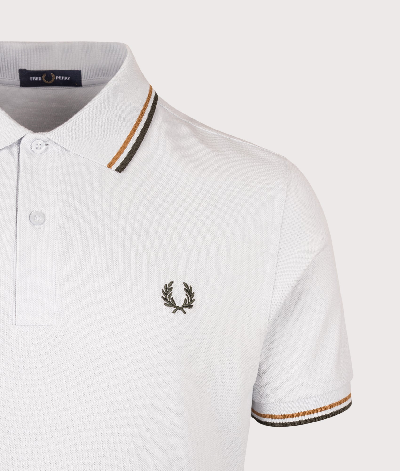 Fred Perry Twin Tipped Polo Shirt in Dusky Blue, Dark Caramel and Night Green at EQVVS Menswear. Detail shot.