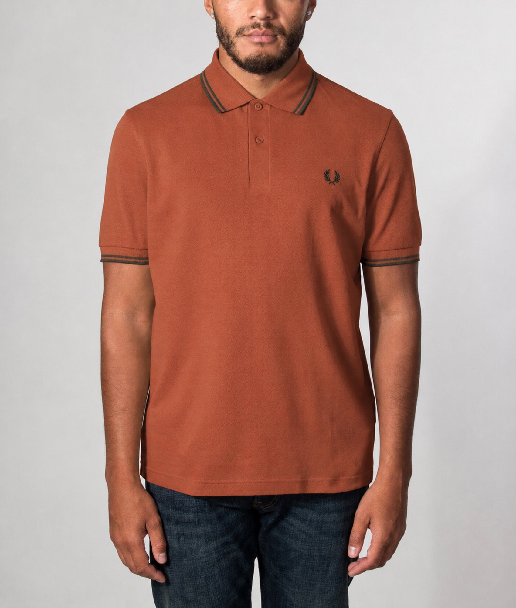 Fred Perry Twin Tipped Polo Shirt in  Brandy and Night Green at EQVVS Menswear. Model front shot.