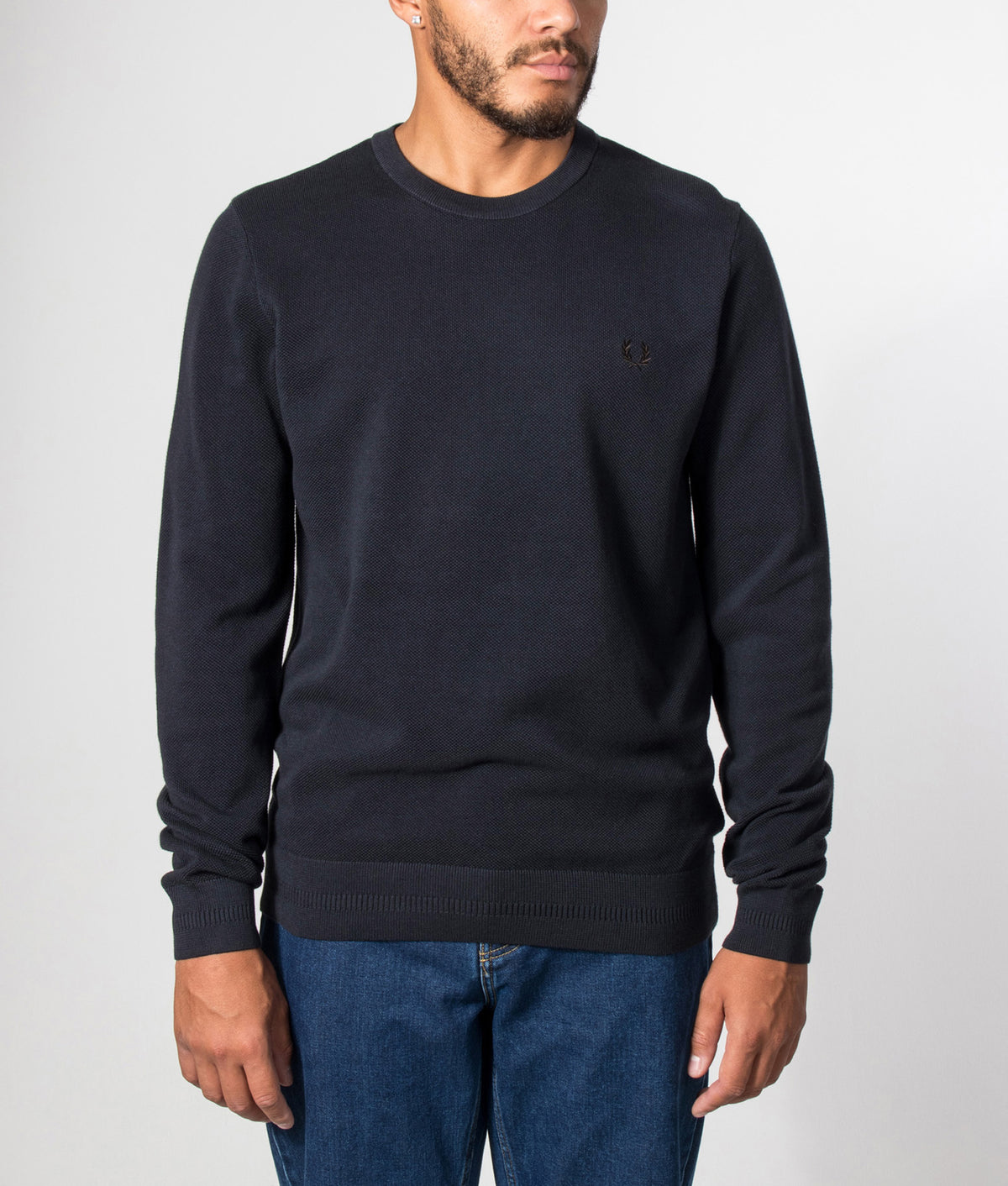 Fred Perry Regular Fit Piqué Stitch Jumper in Navy at EQVVS Menswear. Model front shot.