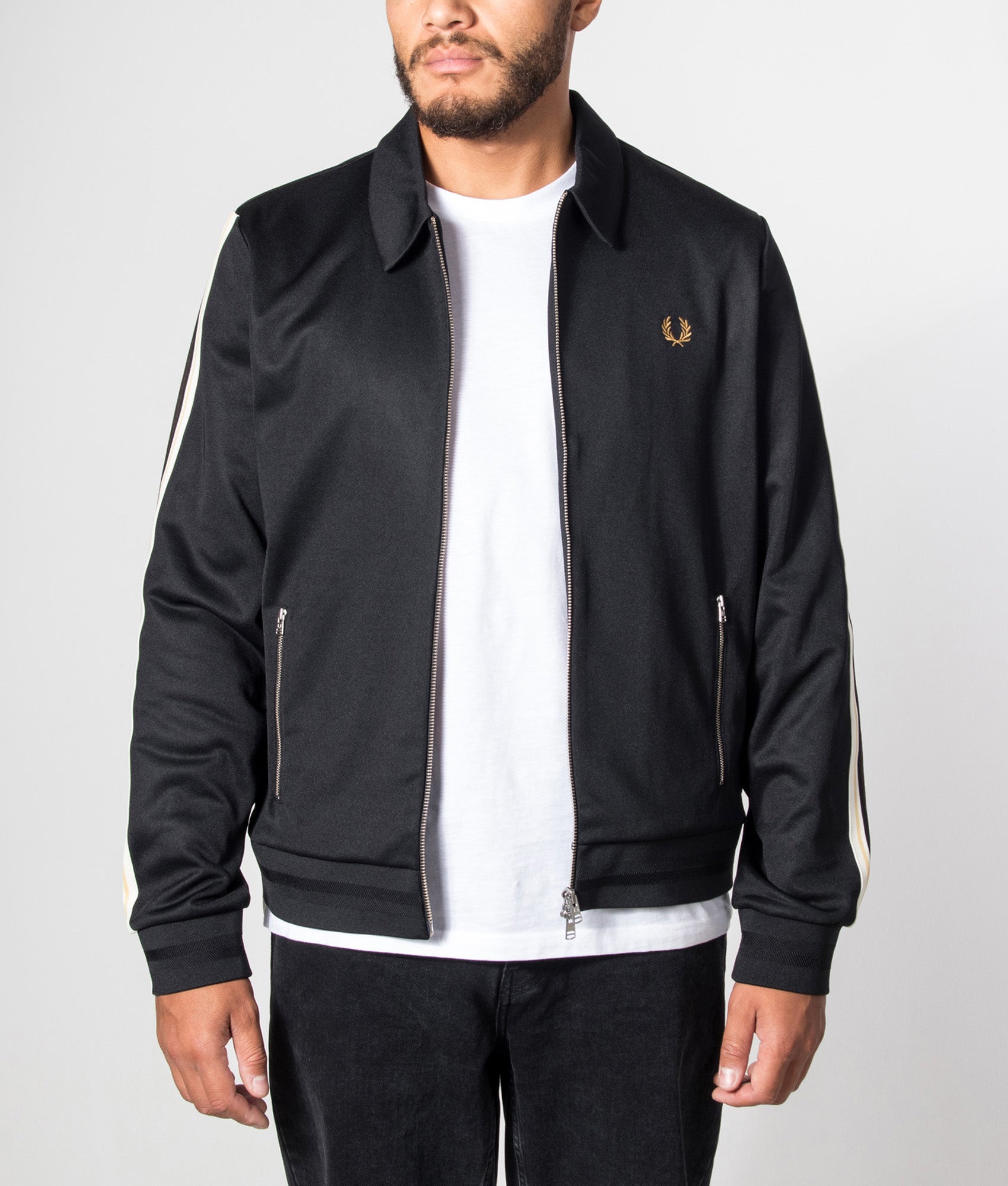Fred Perry Regular Fit Tipped Tape Track Jacket in Black at EQVVS Menswear. Model front shot.