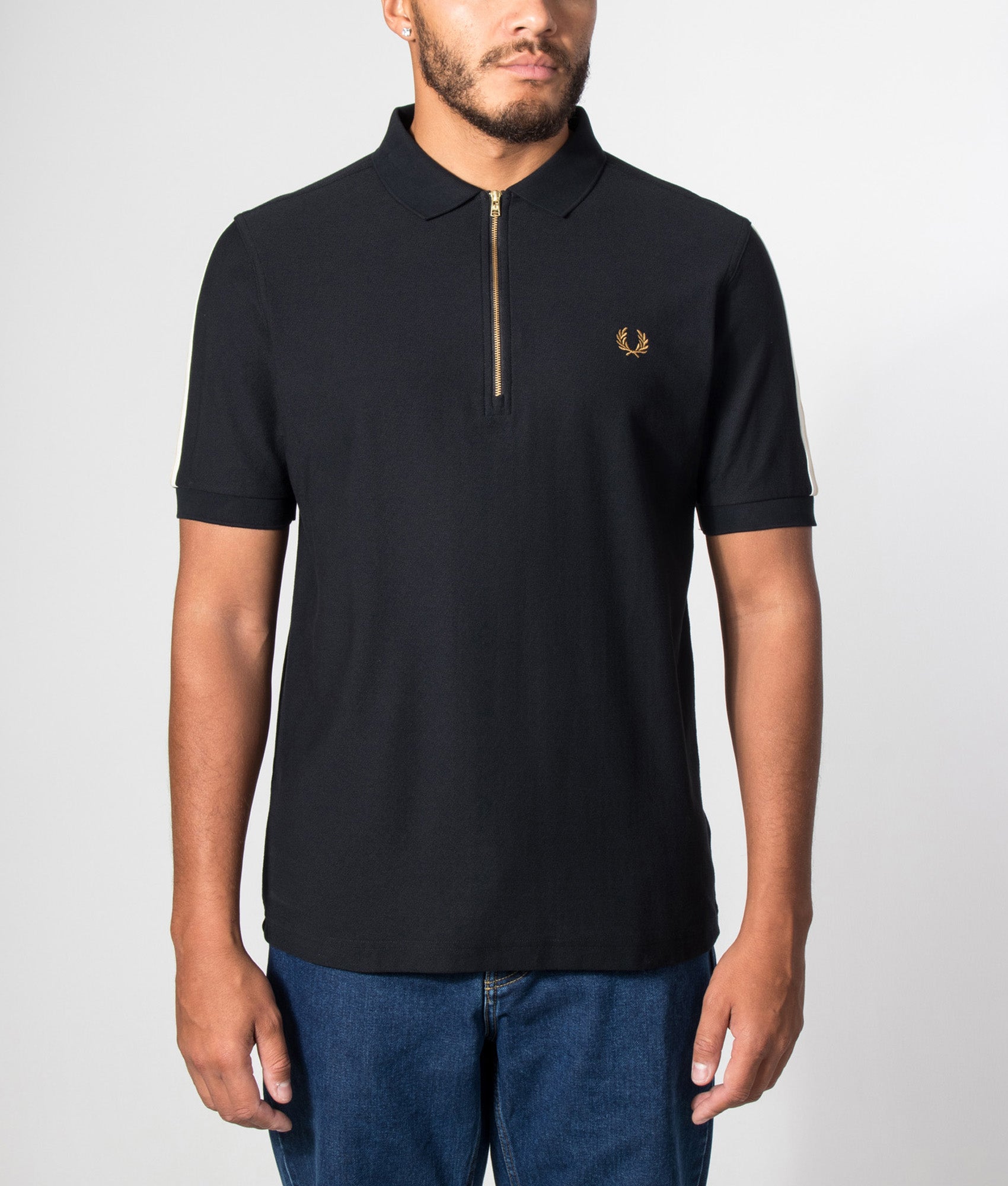Fred Perry Regular Fit Zip Neck Tipped Tape Polo Shirt in Black at EQVVS Menswear. Model front shot.