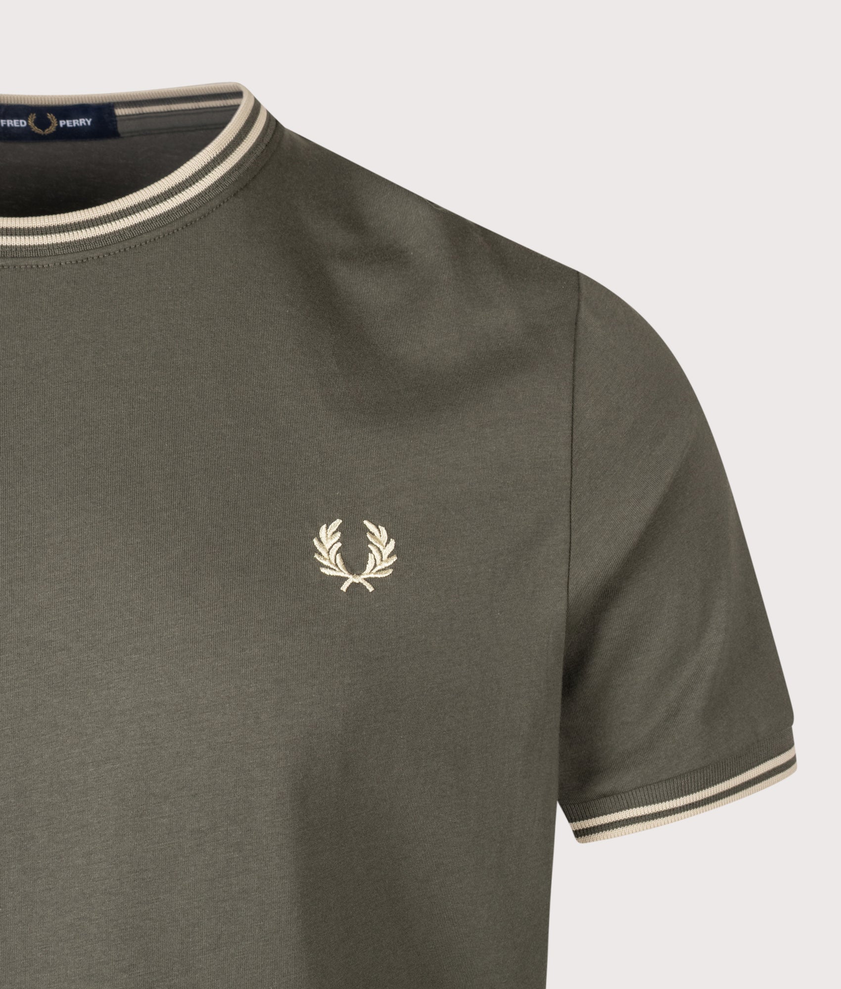 Fred Perry Regular Fit Twin Tipped T-Shirt in Field Green and Oatmeal at EQVVS Menswear. Detail shot.